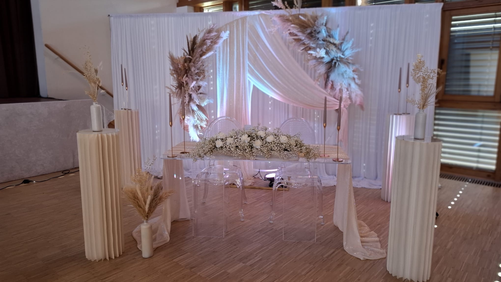 Stilvoll heiraten in den Allgäuer Hörnerdörfern Moderner Trautisch im Boho-Stil mit Trockenblumen, weißem Seidenvorhang, Kerzen