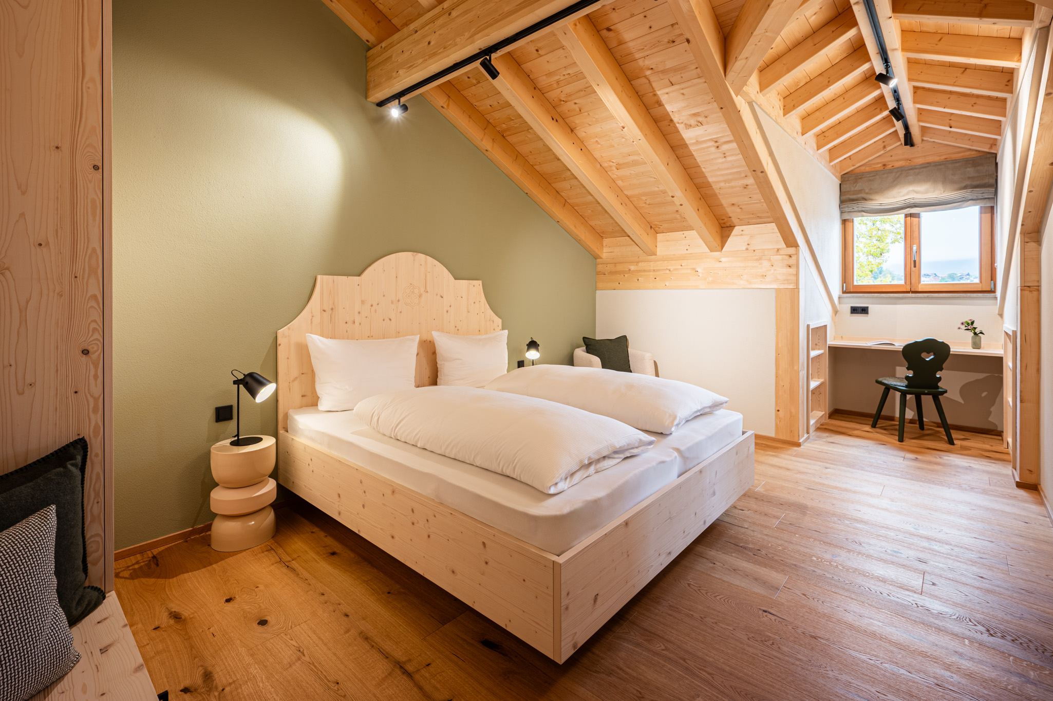Schlafzimmer in Ferienwohnungen MAISEL Ein gemütliches Schlafzimmer mit einem Doppelbett und einem großen Fenster. Die Wände sind in sanften Farbtönen.