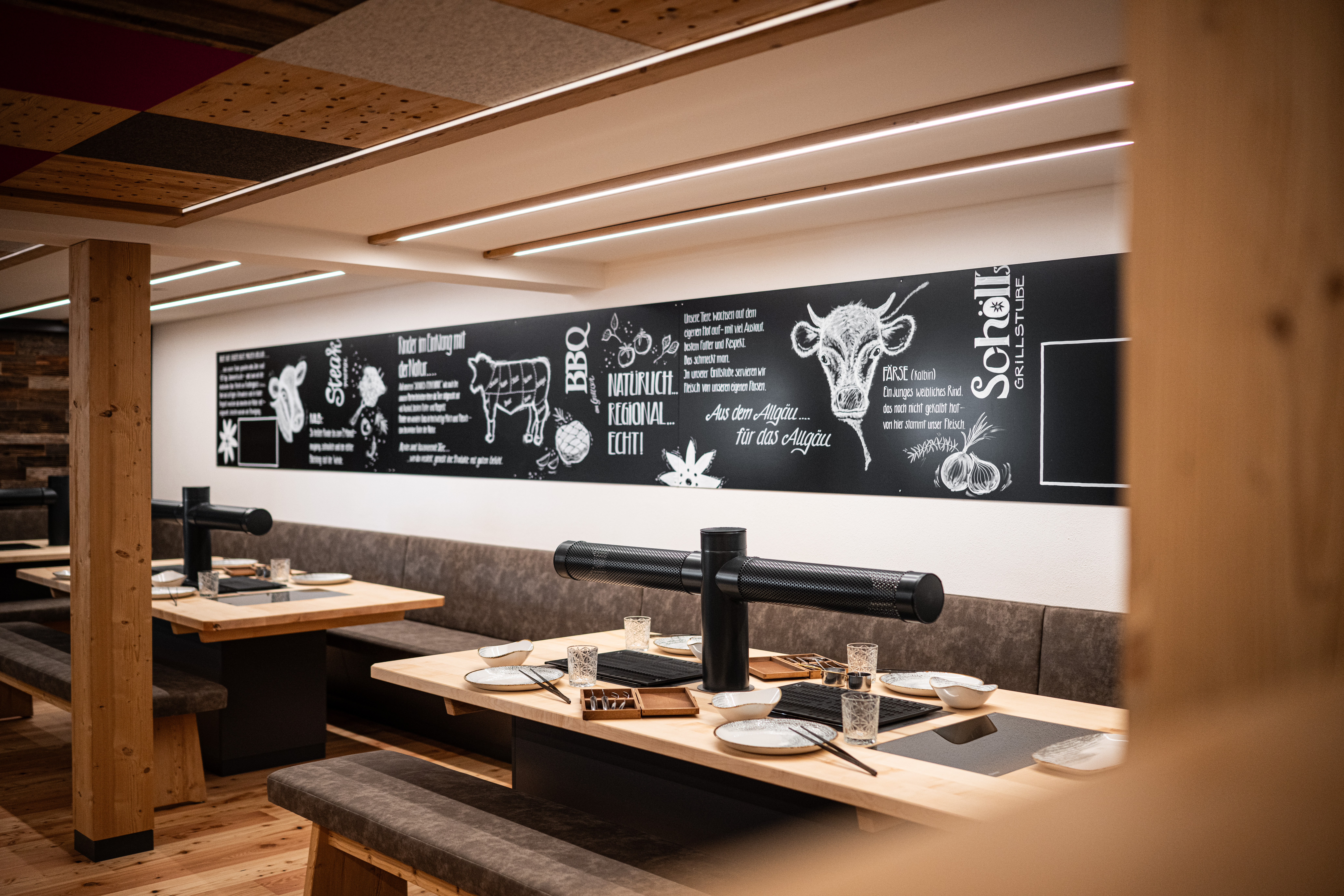 Mehre Tische mit Tischgrill in Holzplatten eingelassen