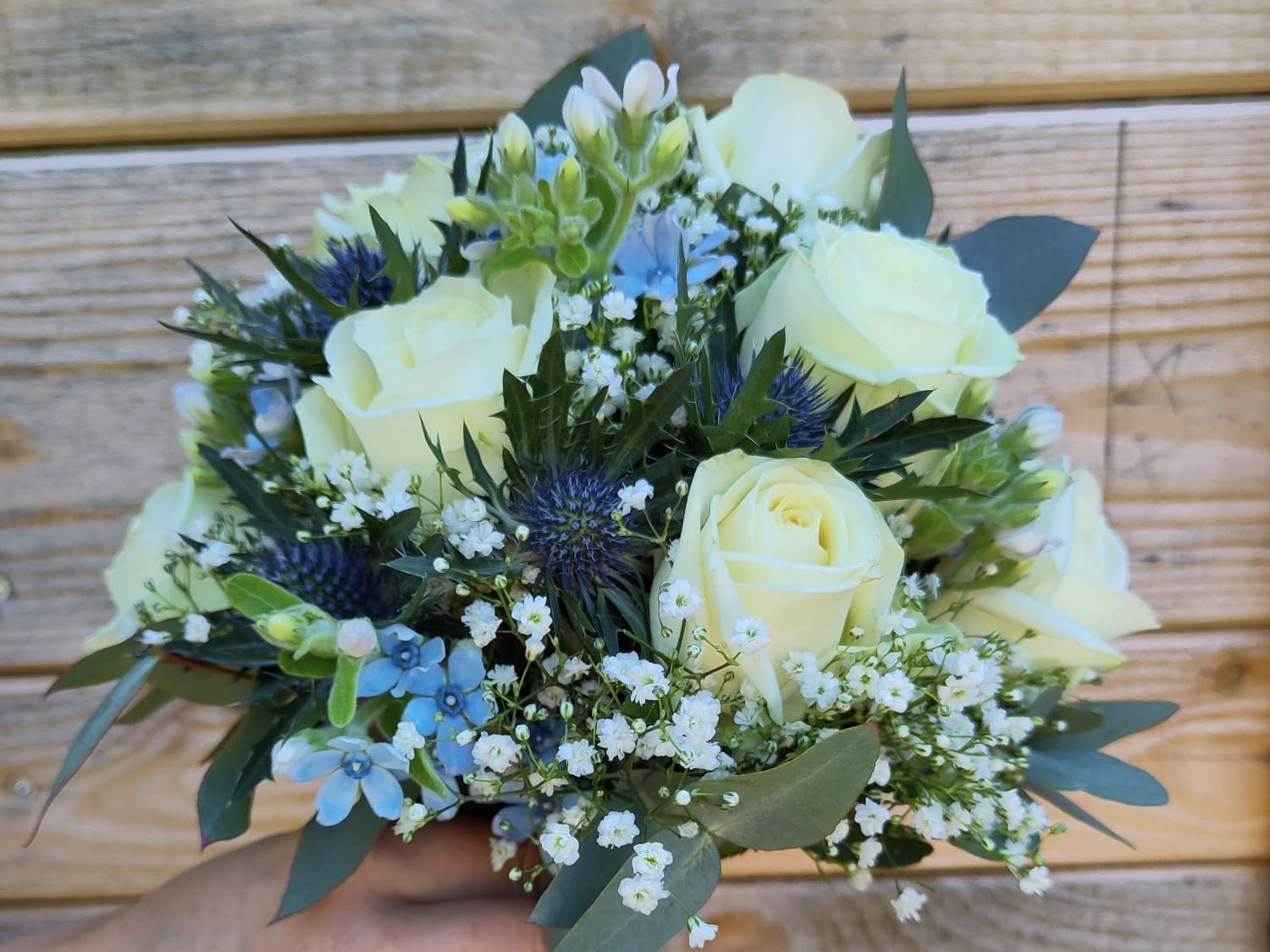 Gebundener Brautstrauß mit weißen Rosen und Schleierkraut 