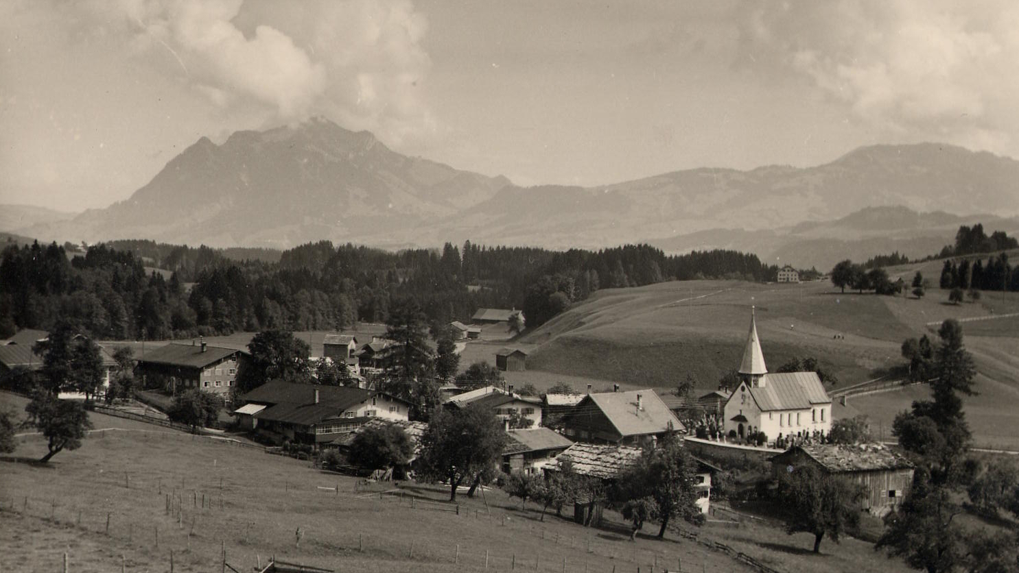 Schwarzweiß-Foto der historischen Ortsansicht von Obermaiselstein, im Hintergrund der Grünten