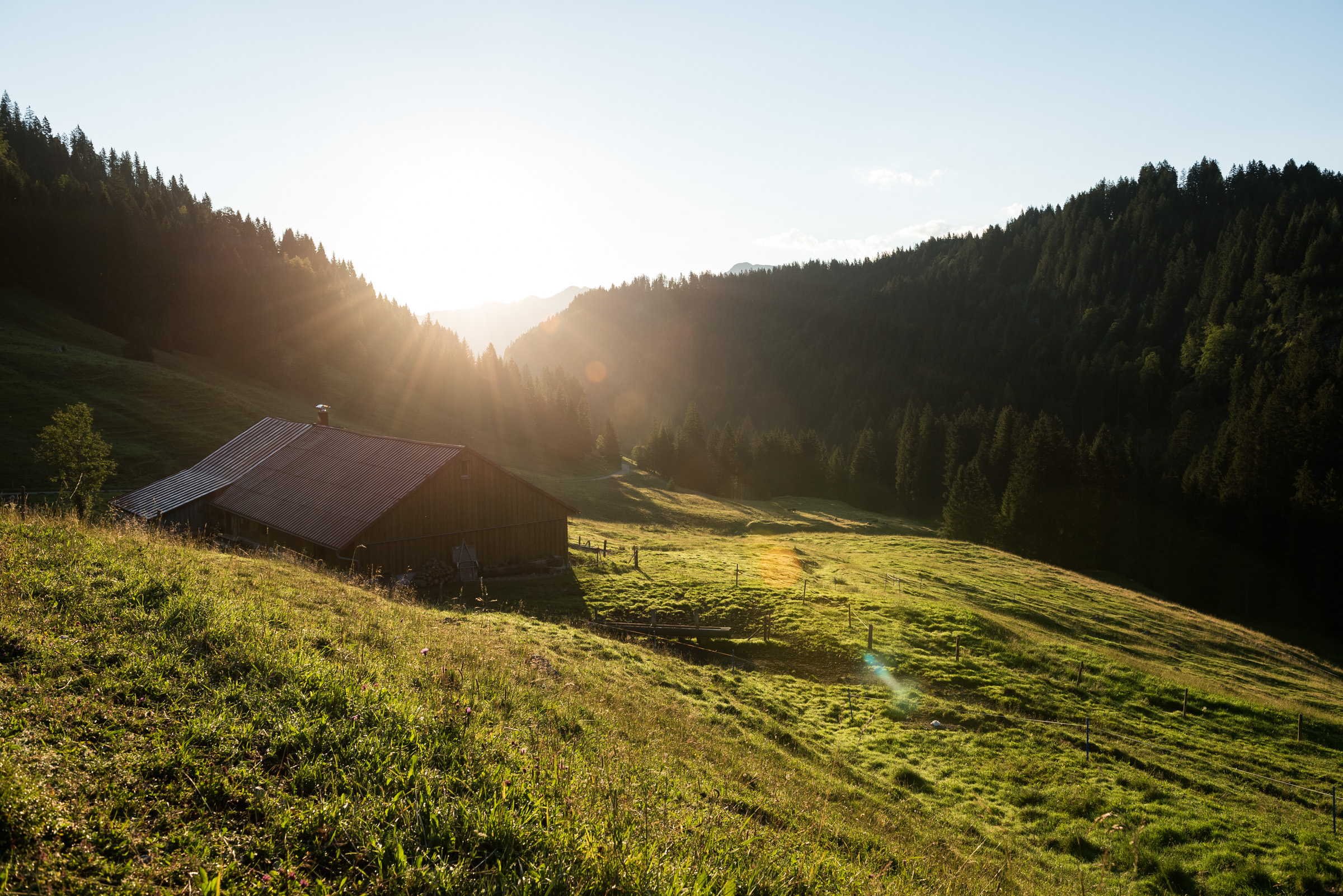 Aufgehende Sonne hinter den Bergen bei der Schwabenalpe in Obermaiselstein