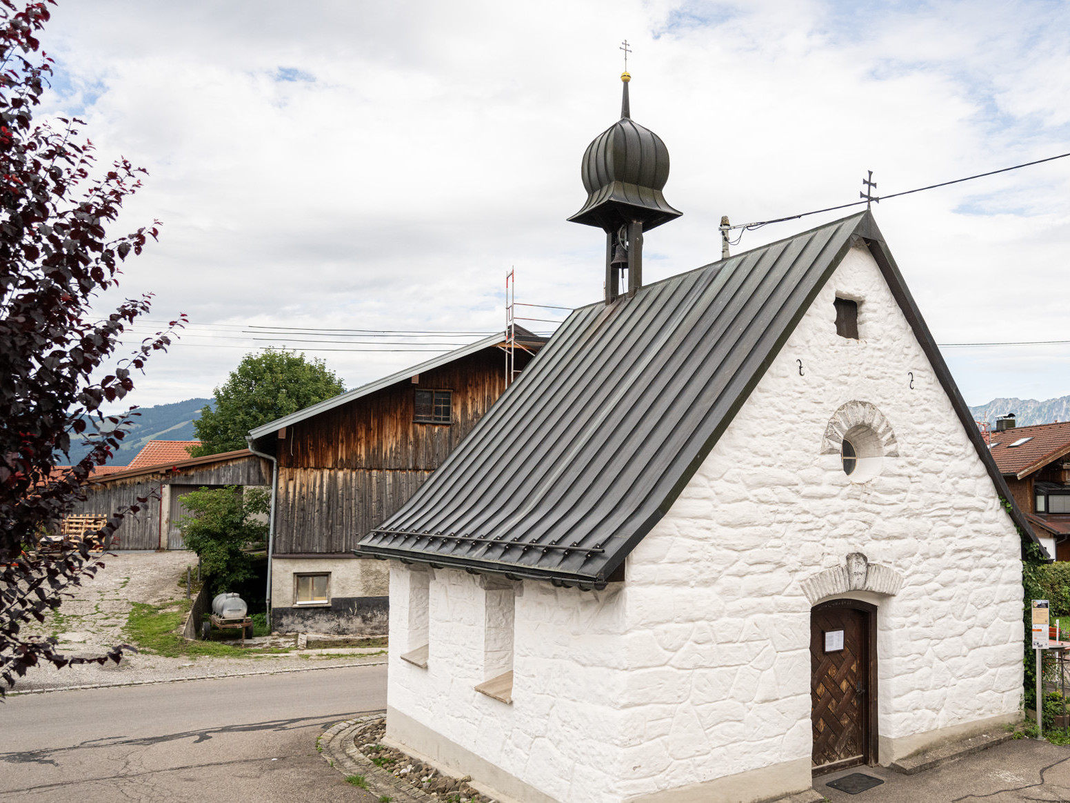 Kapelle in Bolsterlang Sonderdorf, im Hintergrund altes Bauernhaus.