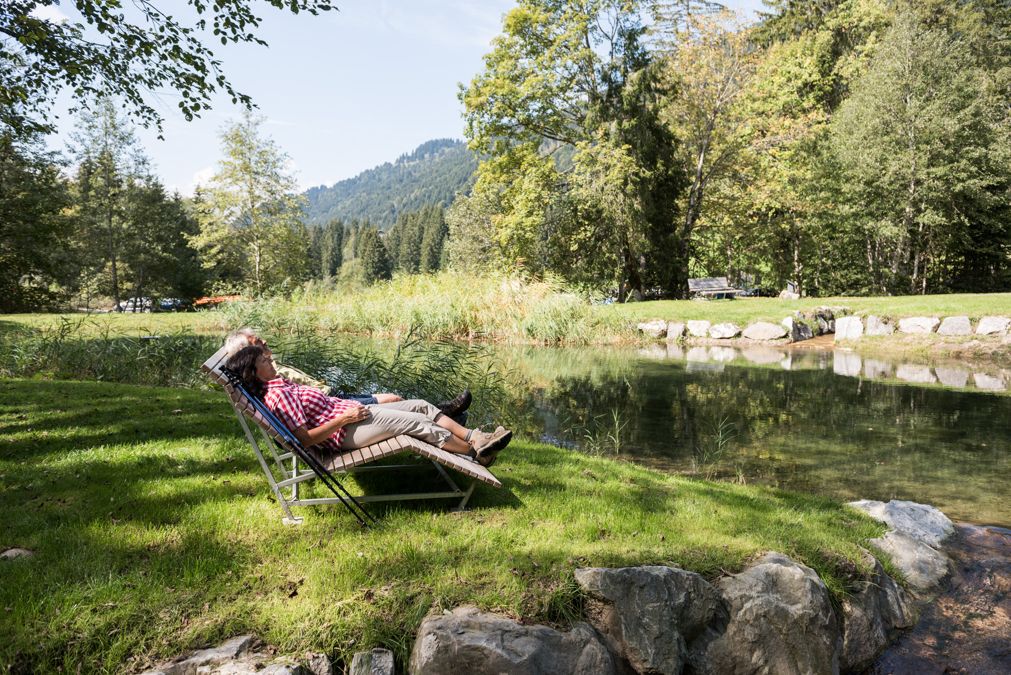 Wanderer liegen auf einer Ruheliege in Balderschwang am Bach