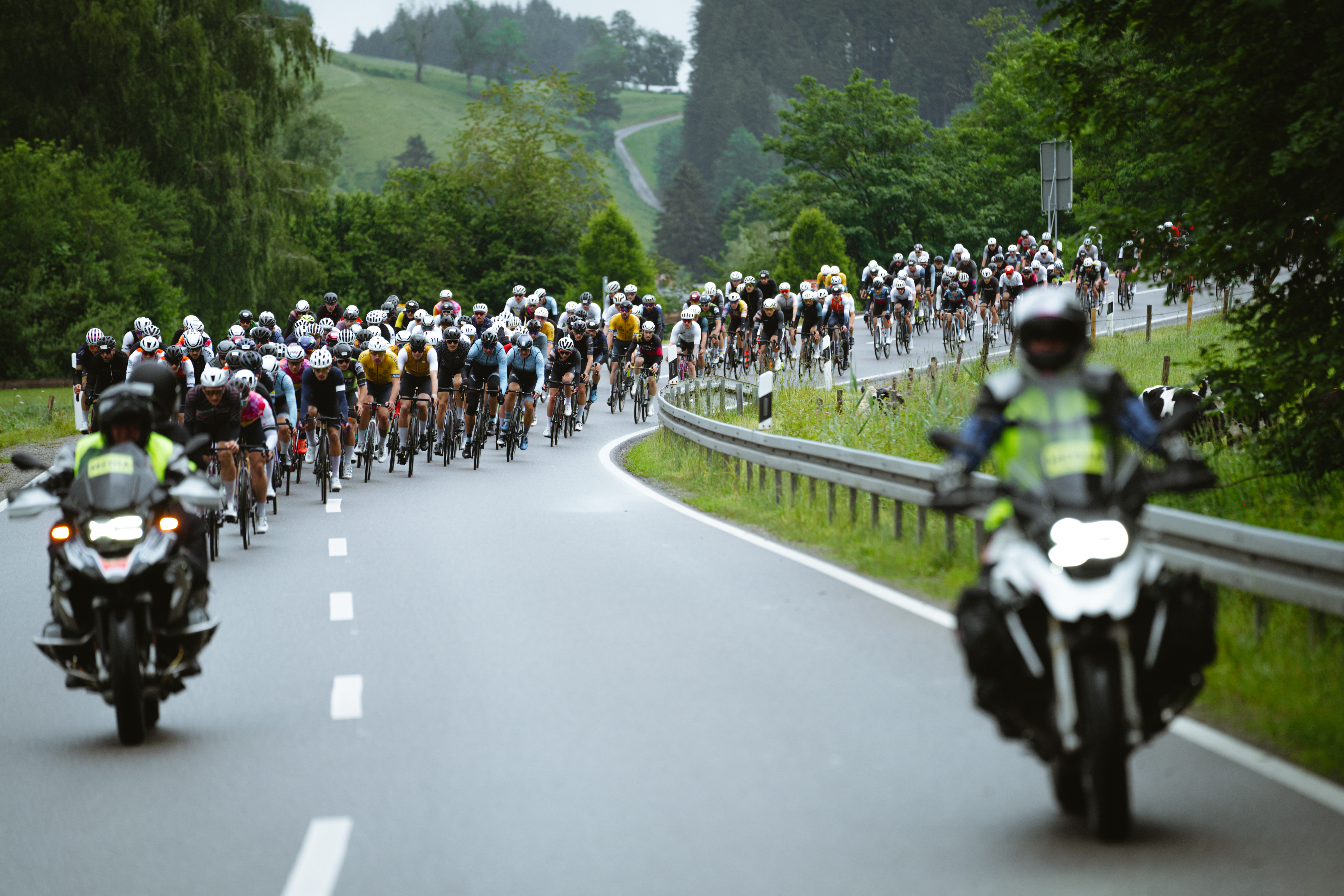 Rennradfahrer auf Tour beim Rad Race One Twenty im Allgäu, davor fahrende Einsatzkräfte auf dem Motorrad | Hörnerdörfer im Allgäu
