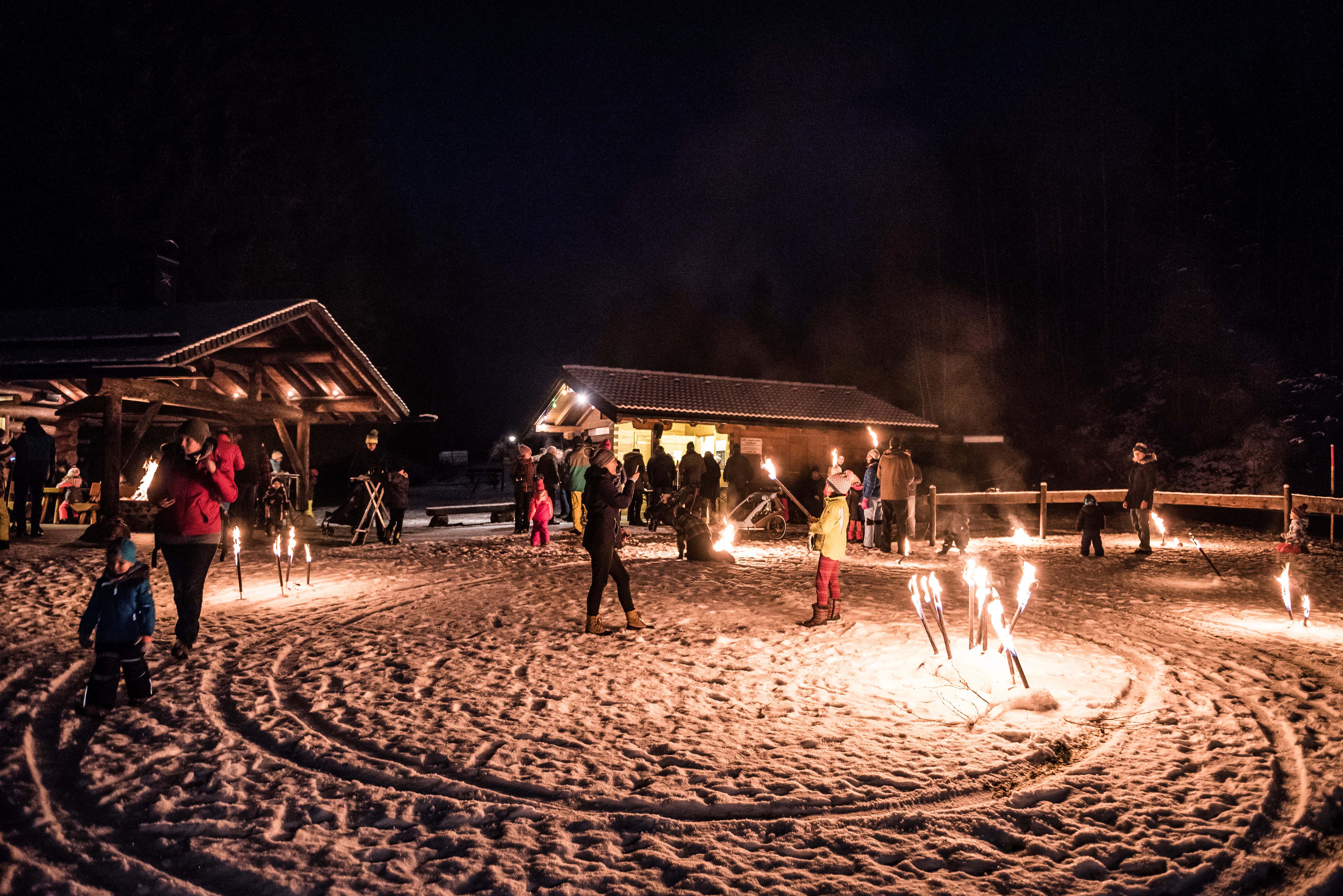 Familien haben sich mit Fackeln im Schnee versammelt