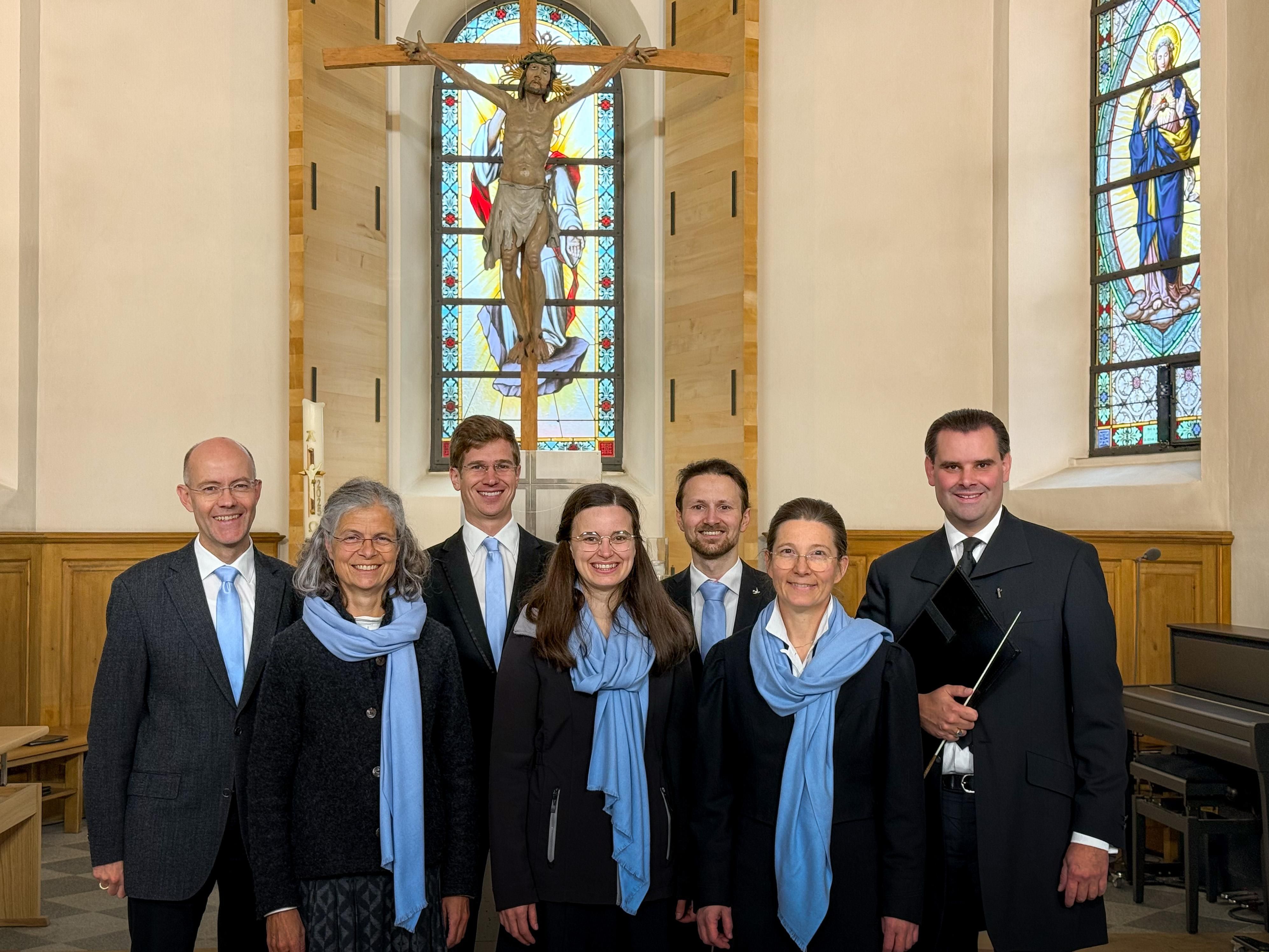 Der sieben Köpfige Chor von Balderschwang steht in der Kirche vor dem Kreuz.