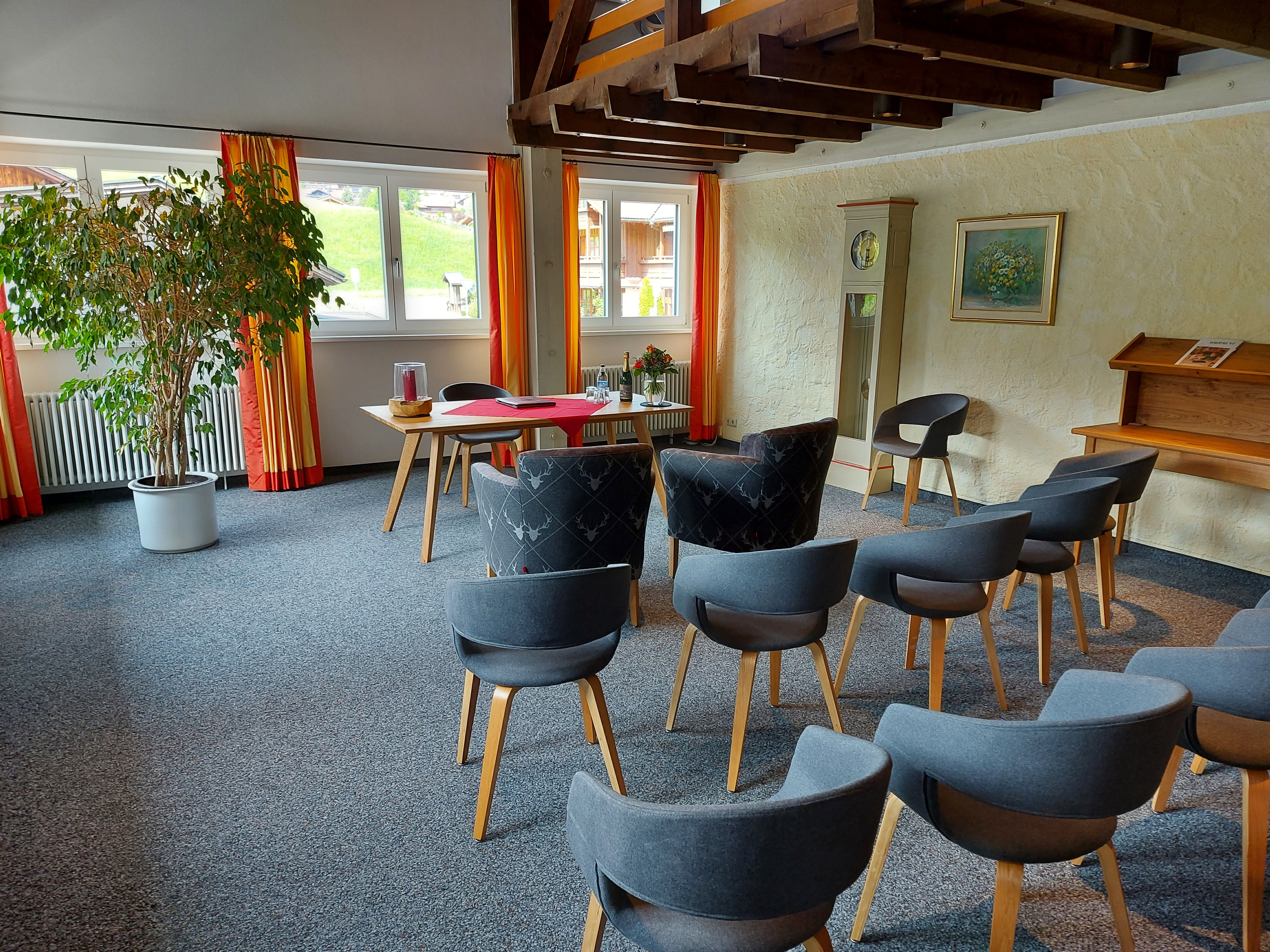 Bestuhlung für kleine Hochzeitsgesellschaft zur standesamtlichen Trauung in Obermaiselstein. Schlichter Trautisch vor drei Fenstern.