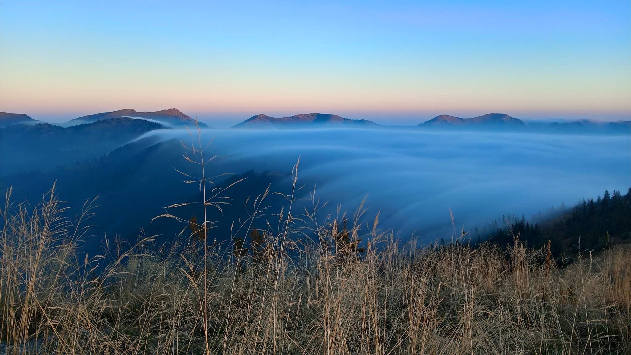 Nebel zieht bei Sonnenaufgang über Bergkamm beim Riedbergerhorn.