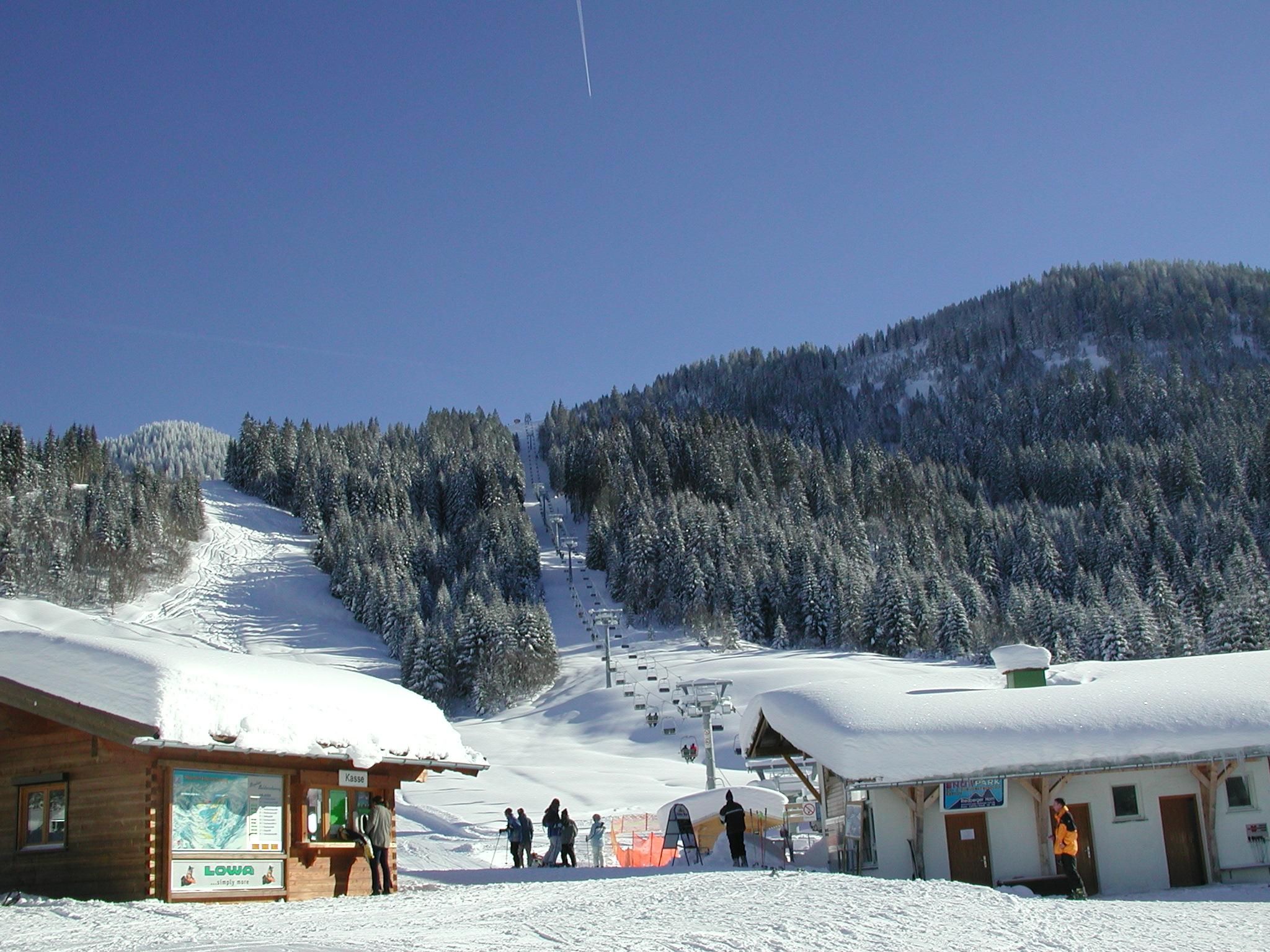 Riedbergerhornliftkasse im Vordergrund und im Hintergrund ein Zweier Sessellift