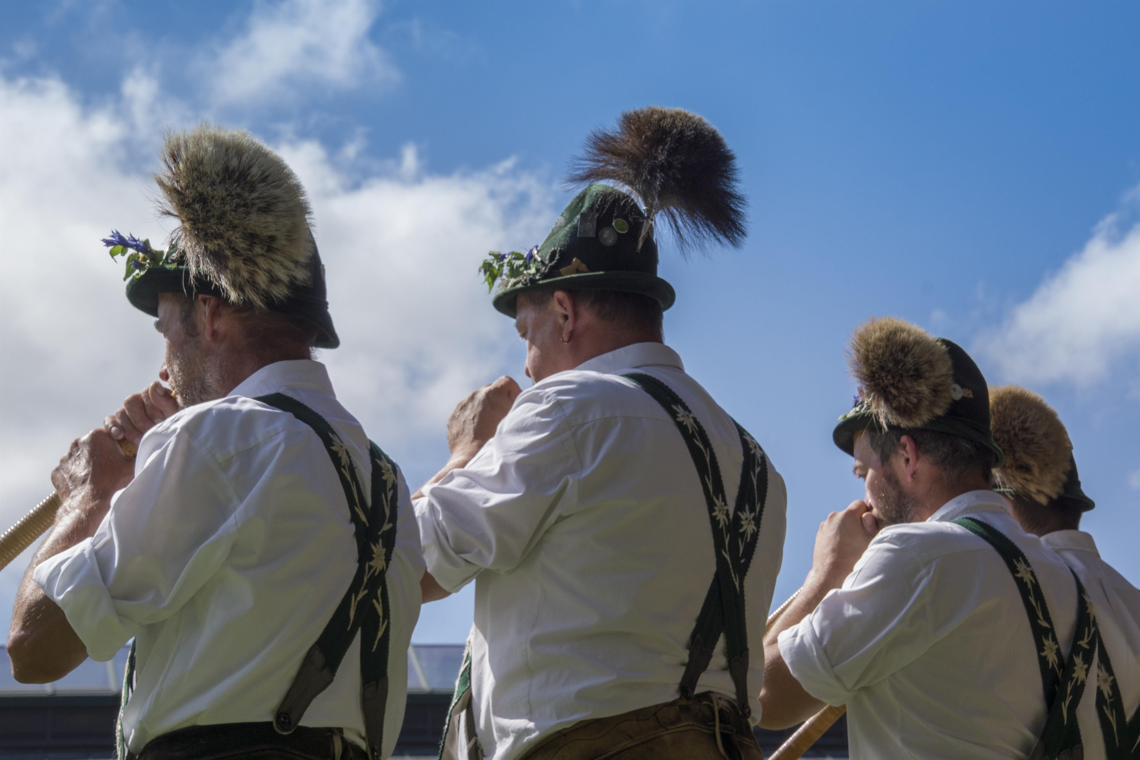Drei Alphornbläser, Ansicht von hinten.