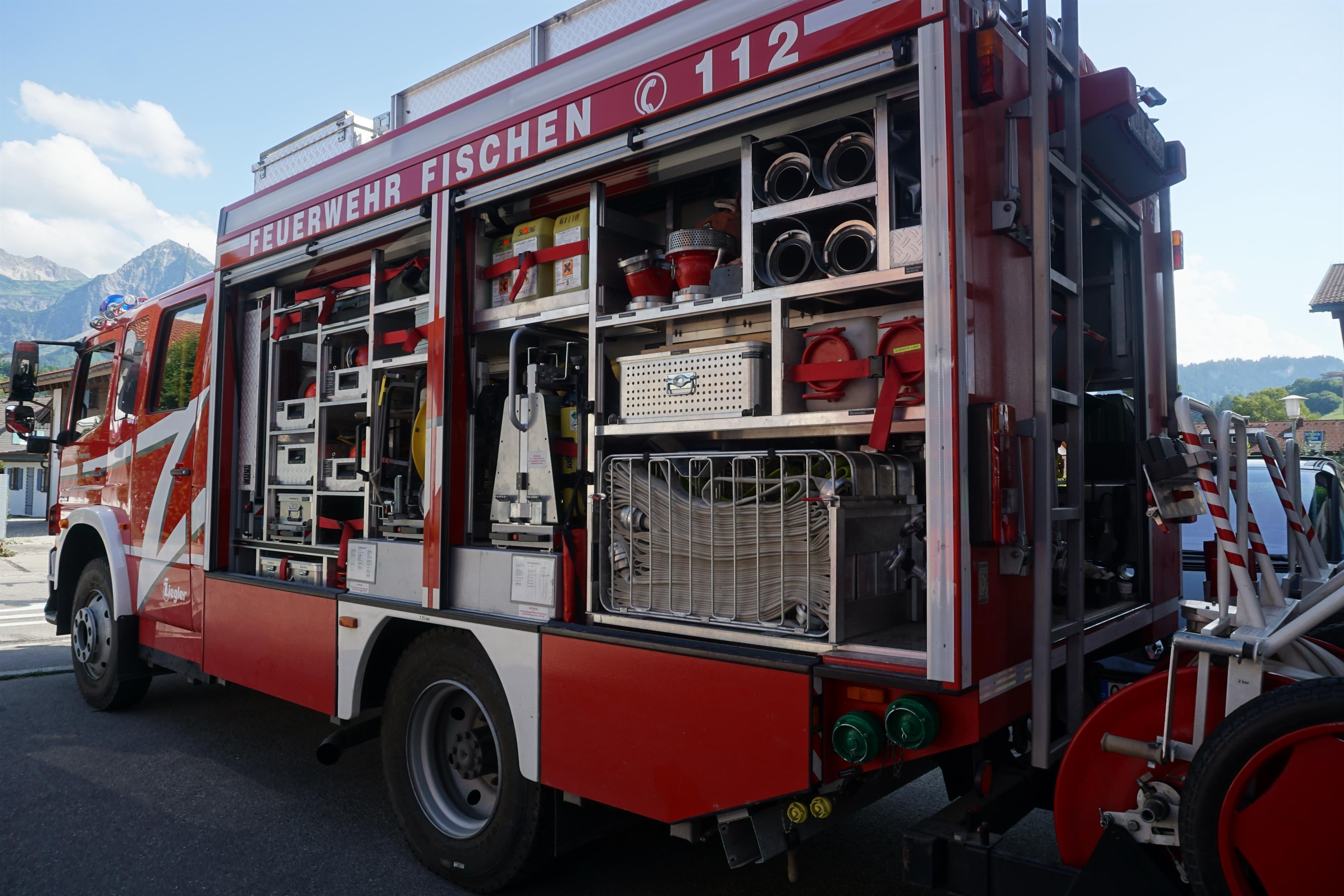 Ein Feuerwehrfahrzeug, die linke Seite ist offen, man sieht alle Ausrüstungsgegenstände.