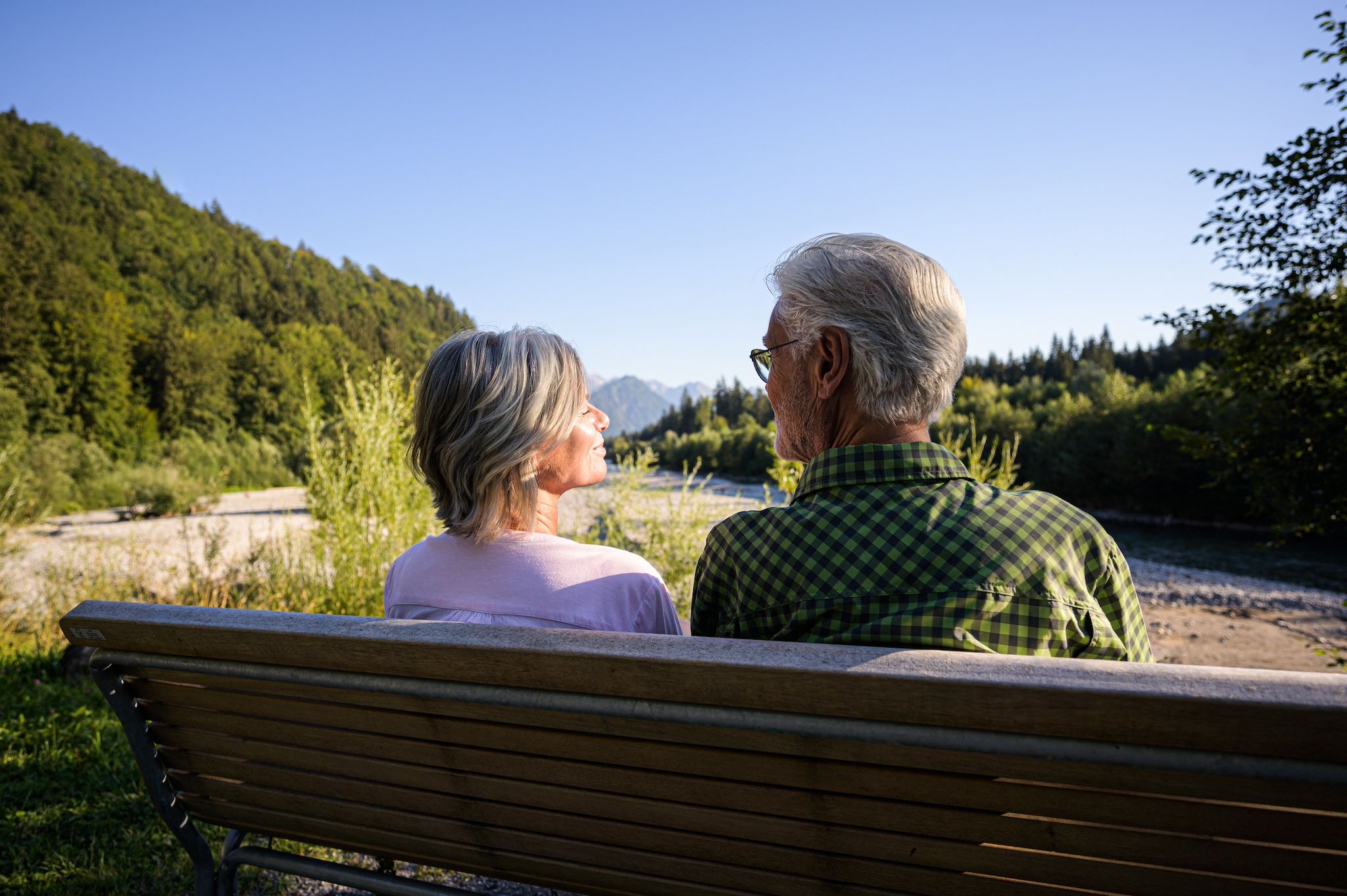 Wanderer genießen Aussicht auf Ruhebank am Auwaldsee