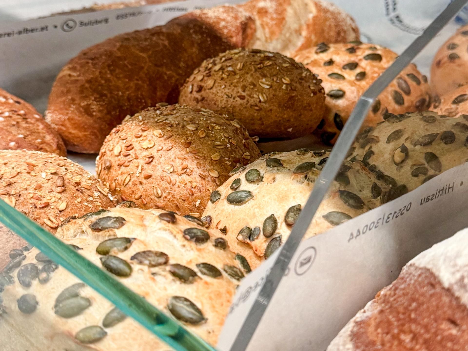 Auslage des Dorfladens Kienle mit verschiedenen frischen Backwaren wie Brötchen mit Kürbiskernen und Sonnenblumenkernen.