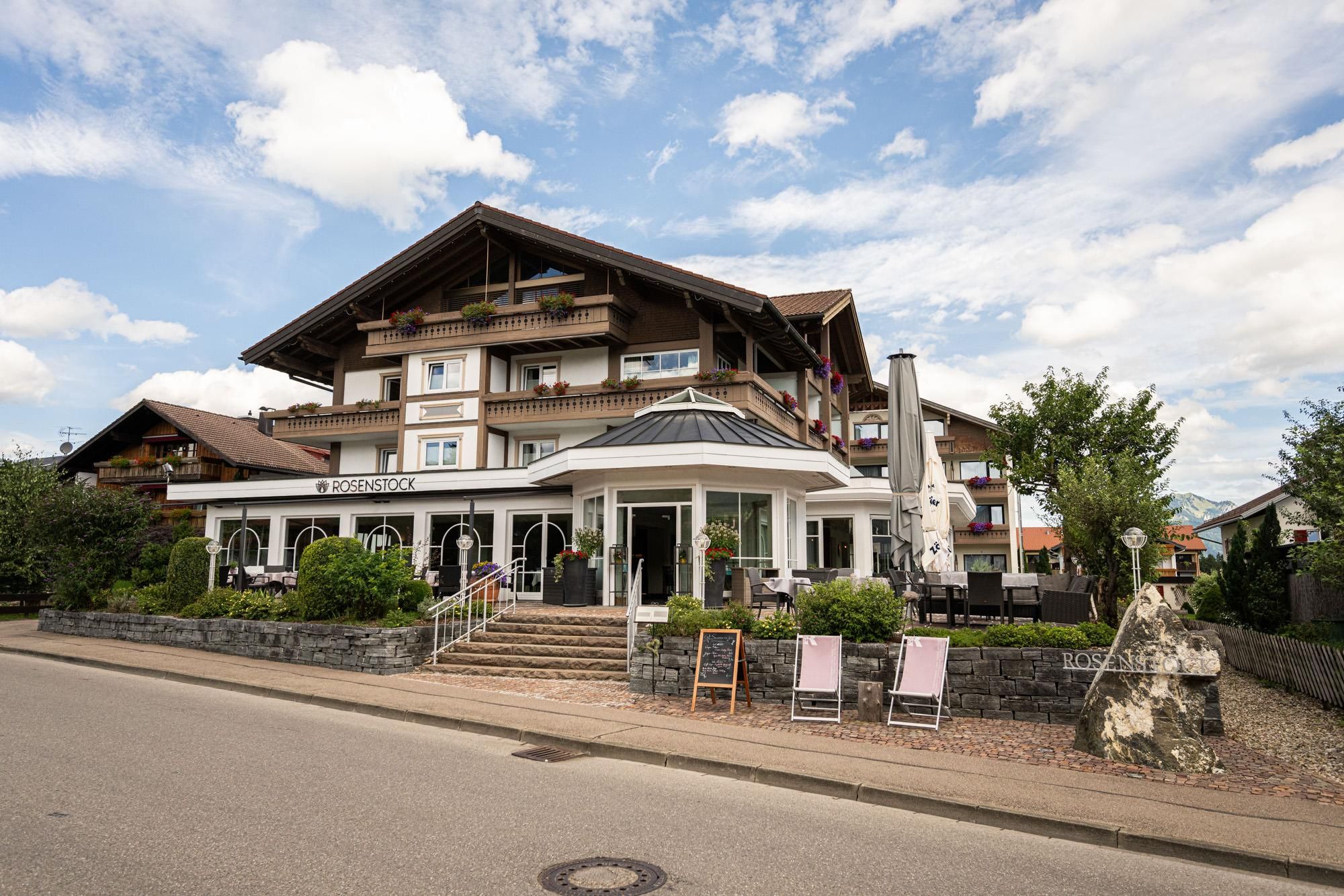 Außenansicht des Hotel Café Rosenstock in Fischen mit Wintergarten und Glaskuppel.