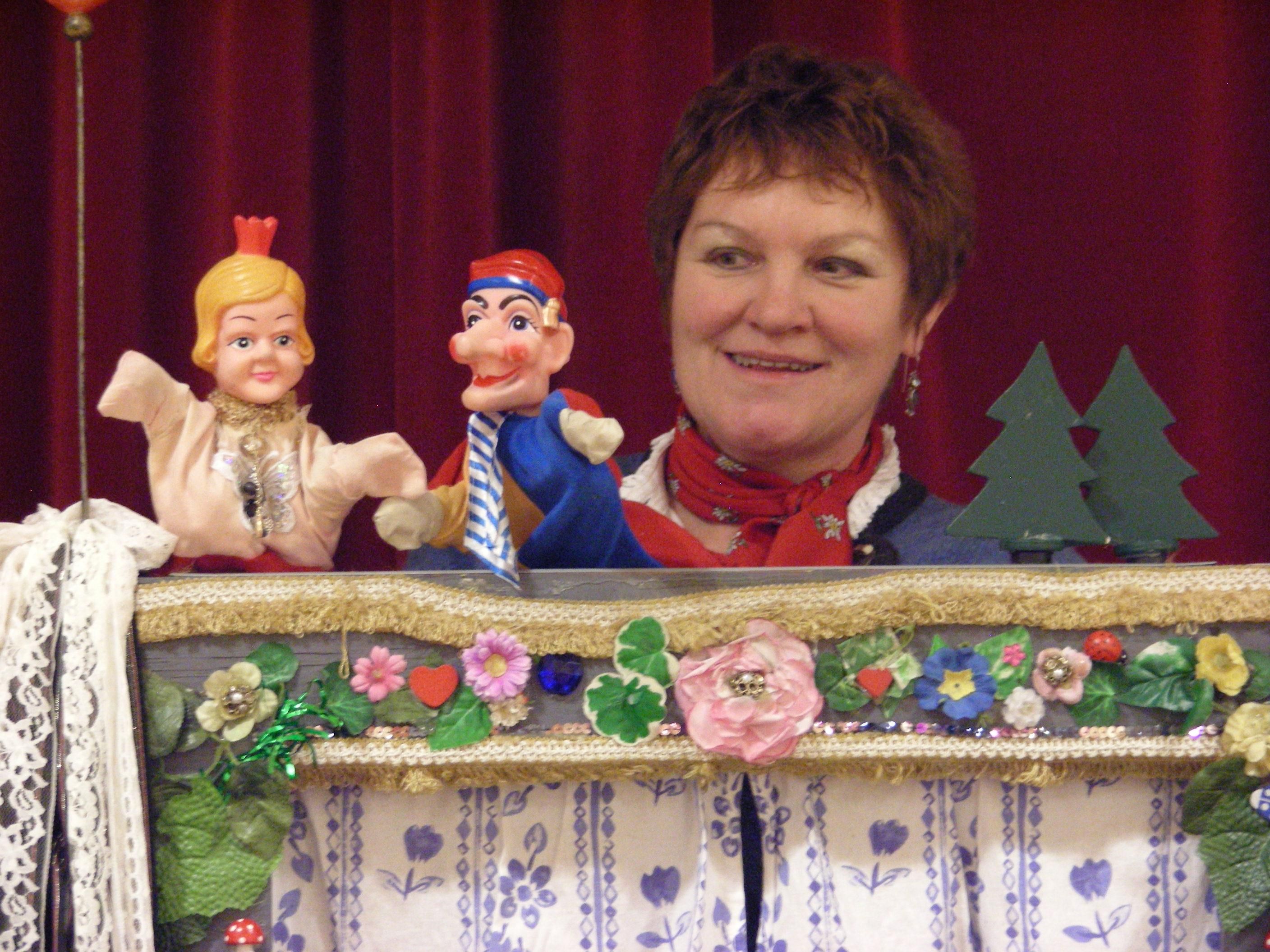 Die Puppenspielerin präsentiert hier zwei ihrer Figuren: eine Prinzessin links mit kleiner Krone und das Kasperle rechts.