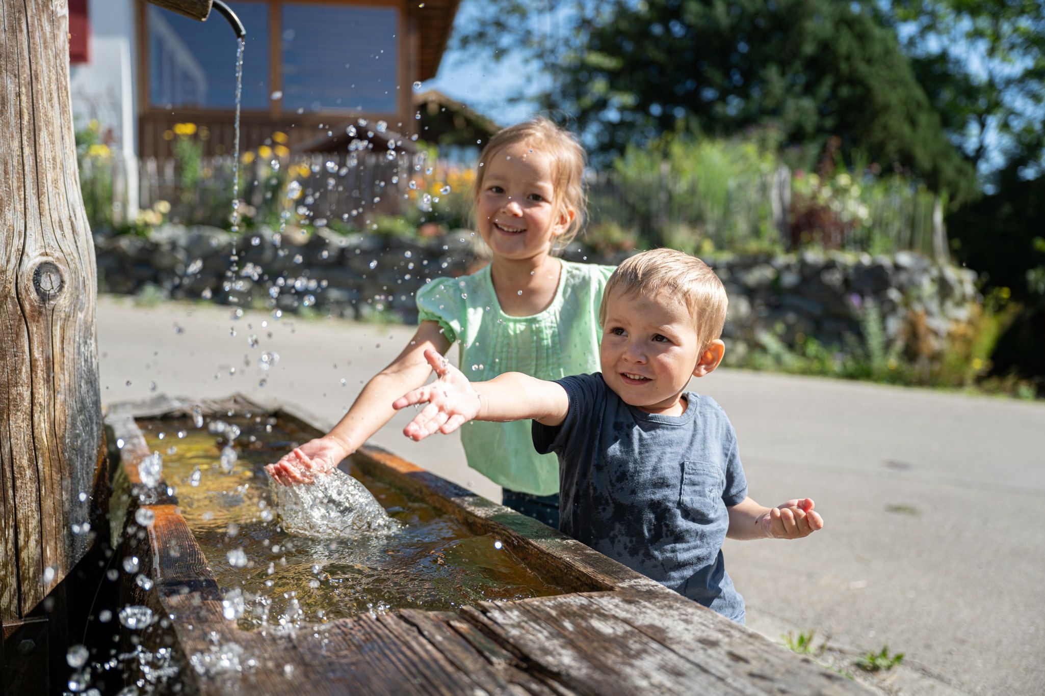Kinder an einem Brunnen in Bolsterlang im Allgäu