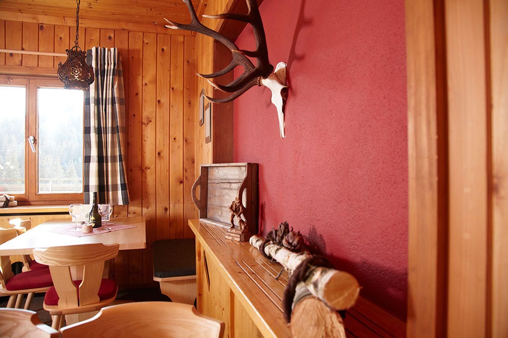 Gemütlicher Innenraum der Grasgehrenhütte. Holzwände und -decke schaffen eine warme Atmosphäre.