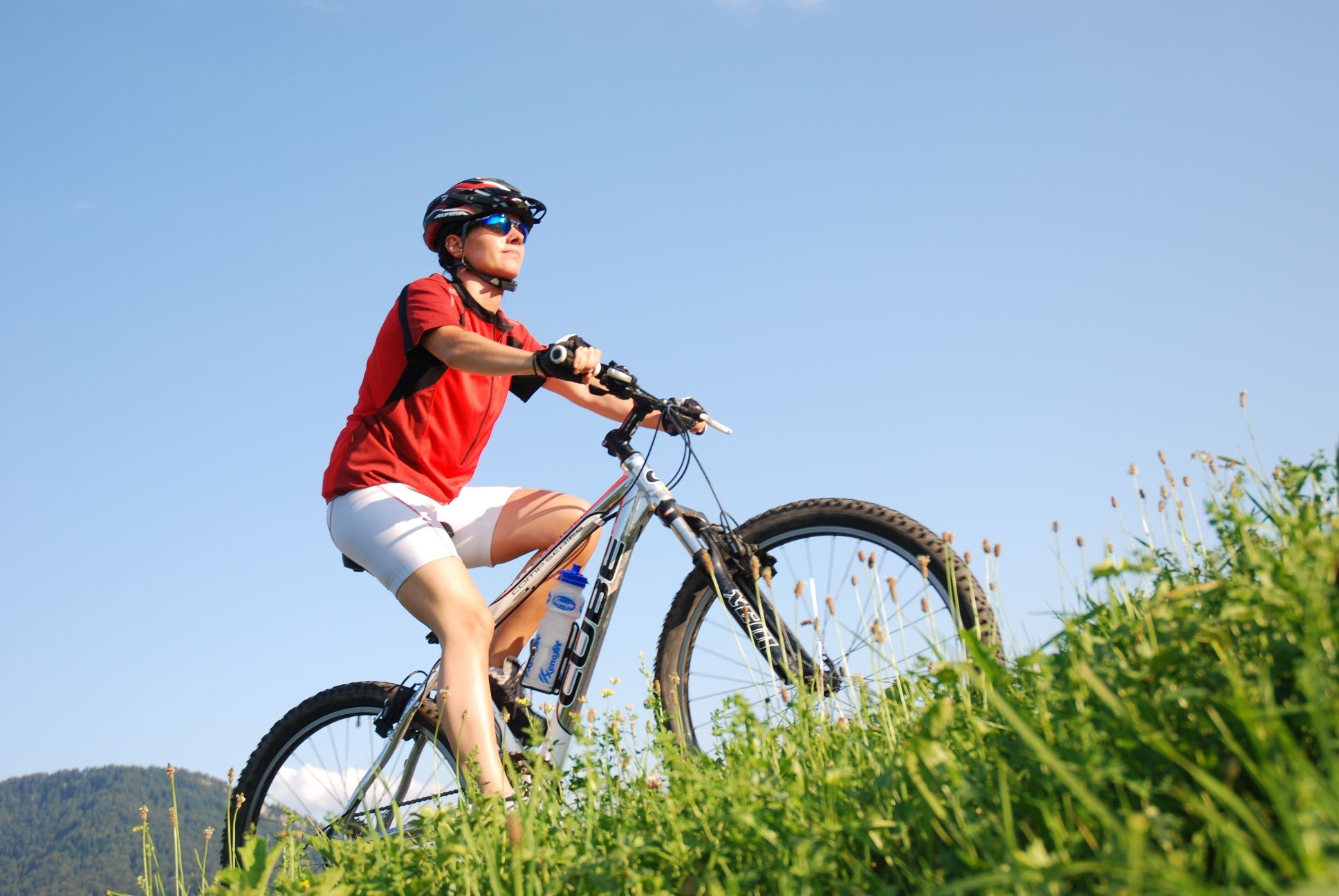 Mountainbiker fährt entlang grüner Wiese