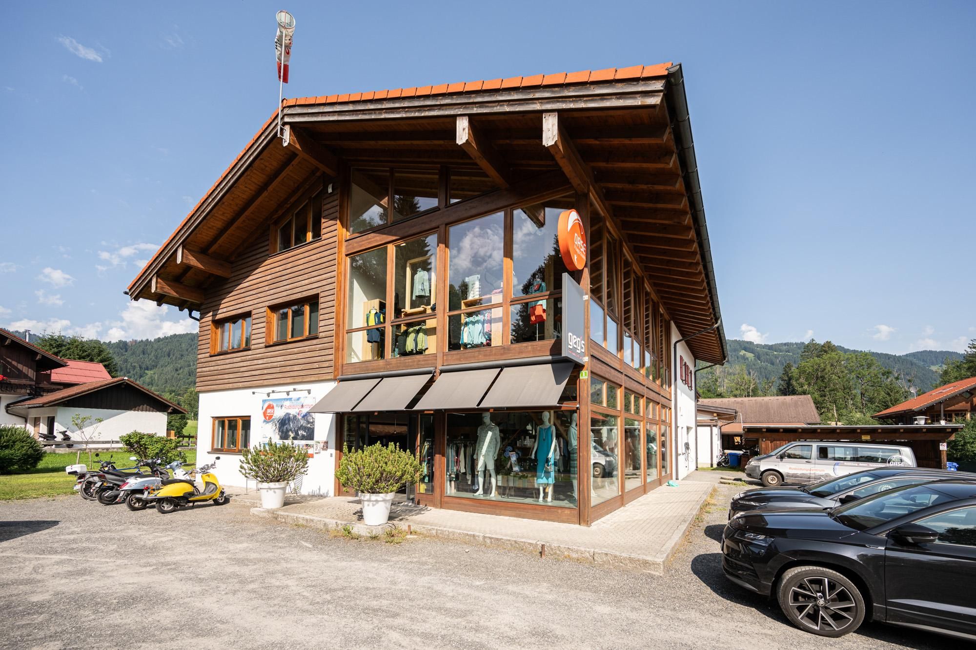 Große Fensterfront mit Schaufensterpuppen, die aktuelle Kleidung präsentieren.
