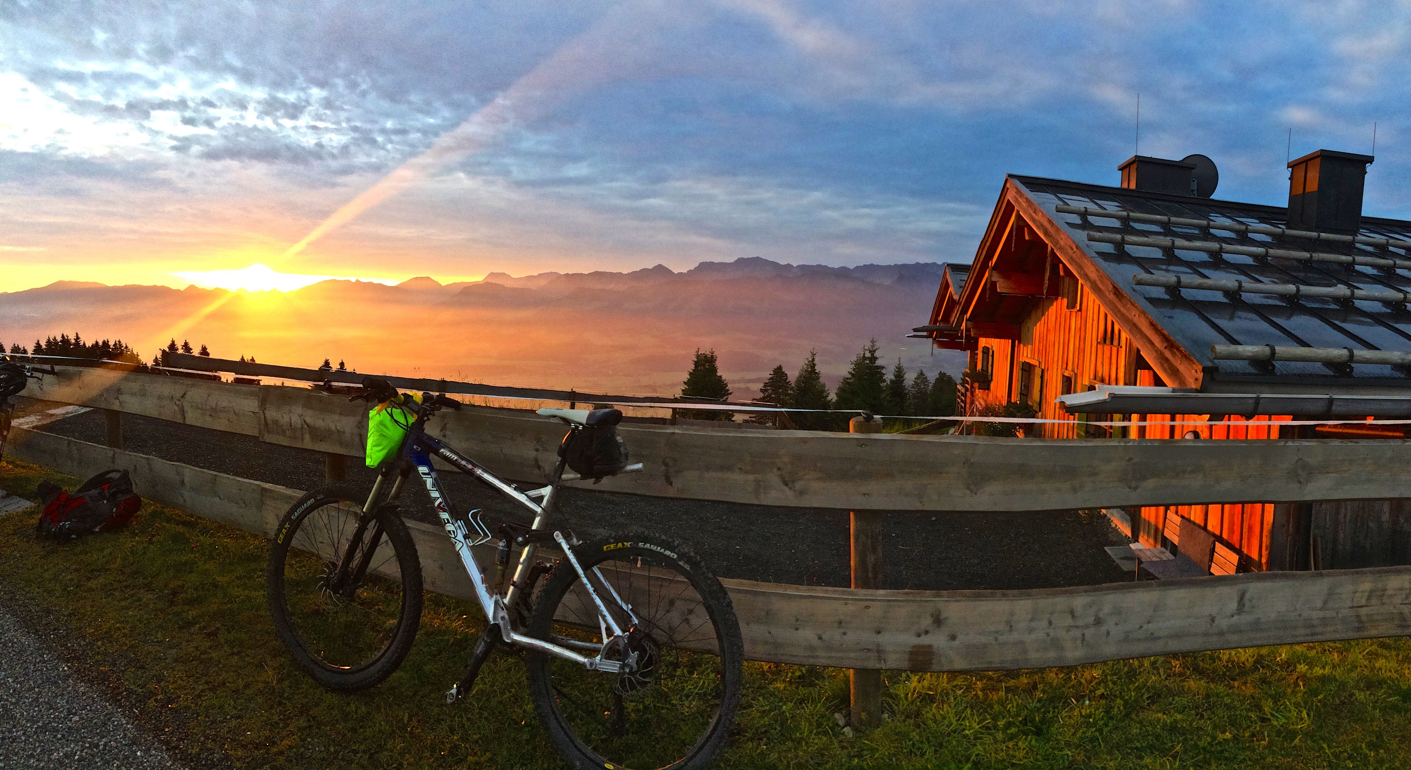 Farbenfroher Sonnenaufgang an der Weltcup-Hütte mit Fahrrad