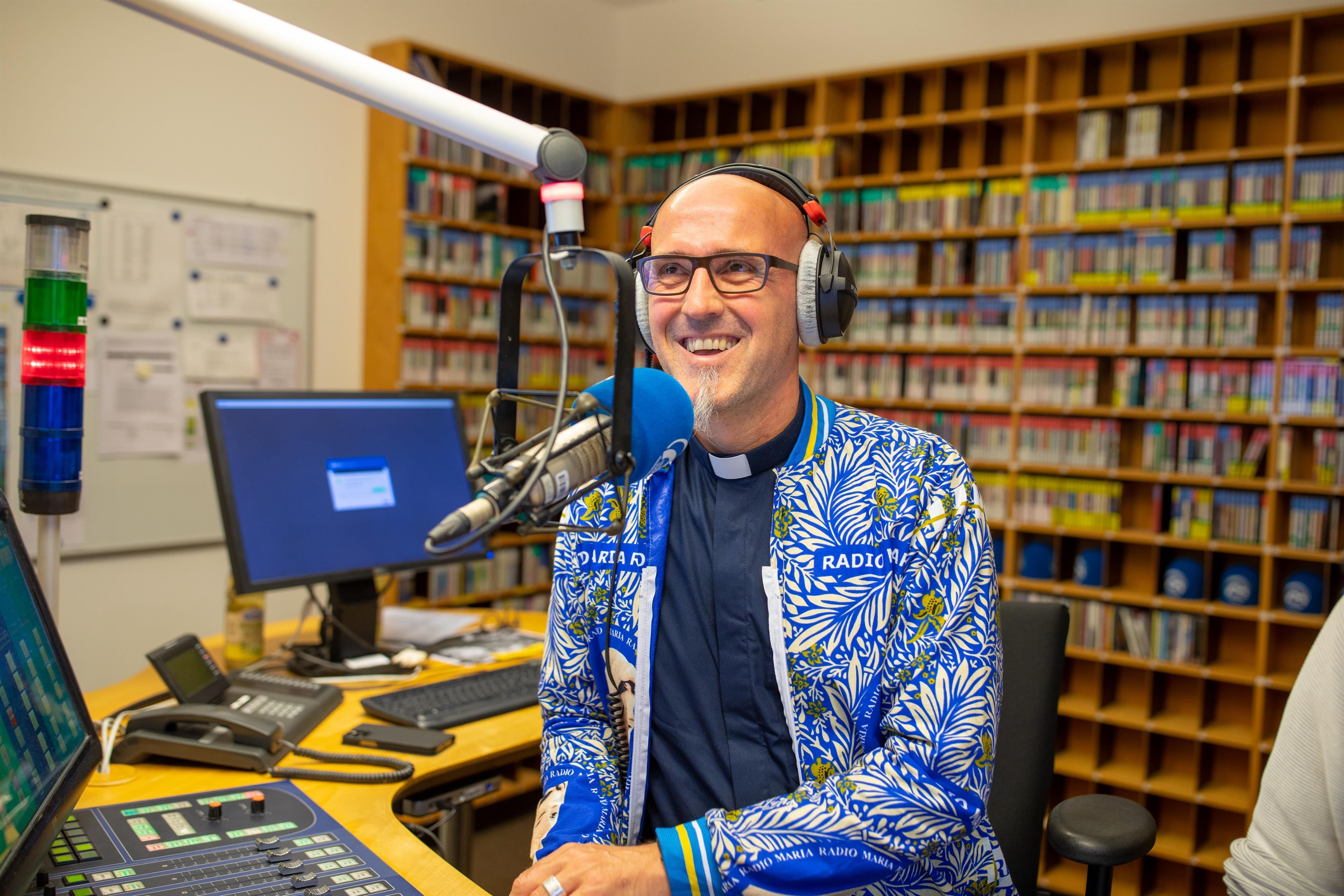 Radiosprecher vom RadioHoreb spricht in ein Mikrofon und hat Kopfhörer an.