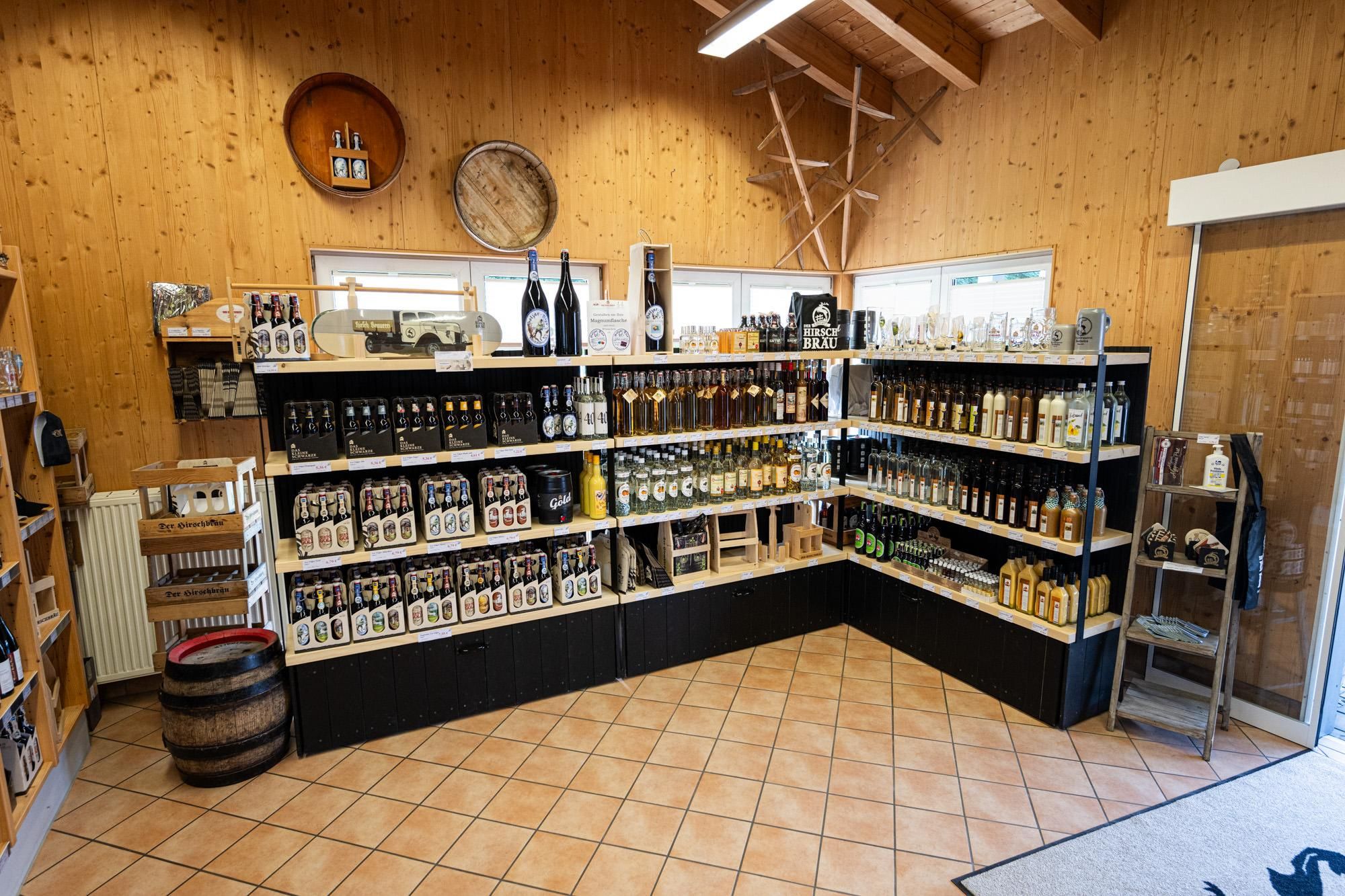Rustikaler Holzstadl des Getränkestadls Obermaiselstein. Dunkelbraunes Holz mit helleren Akzenten.