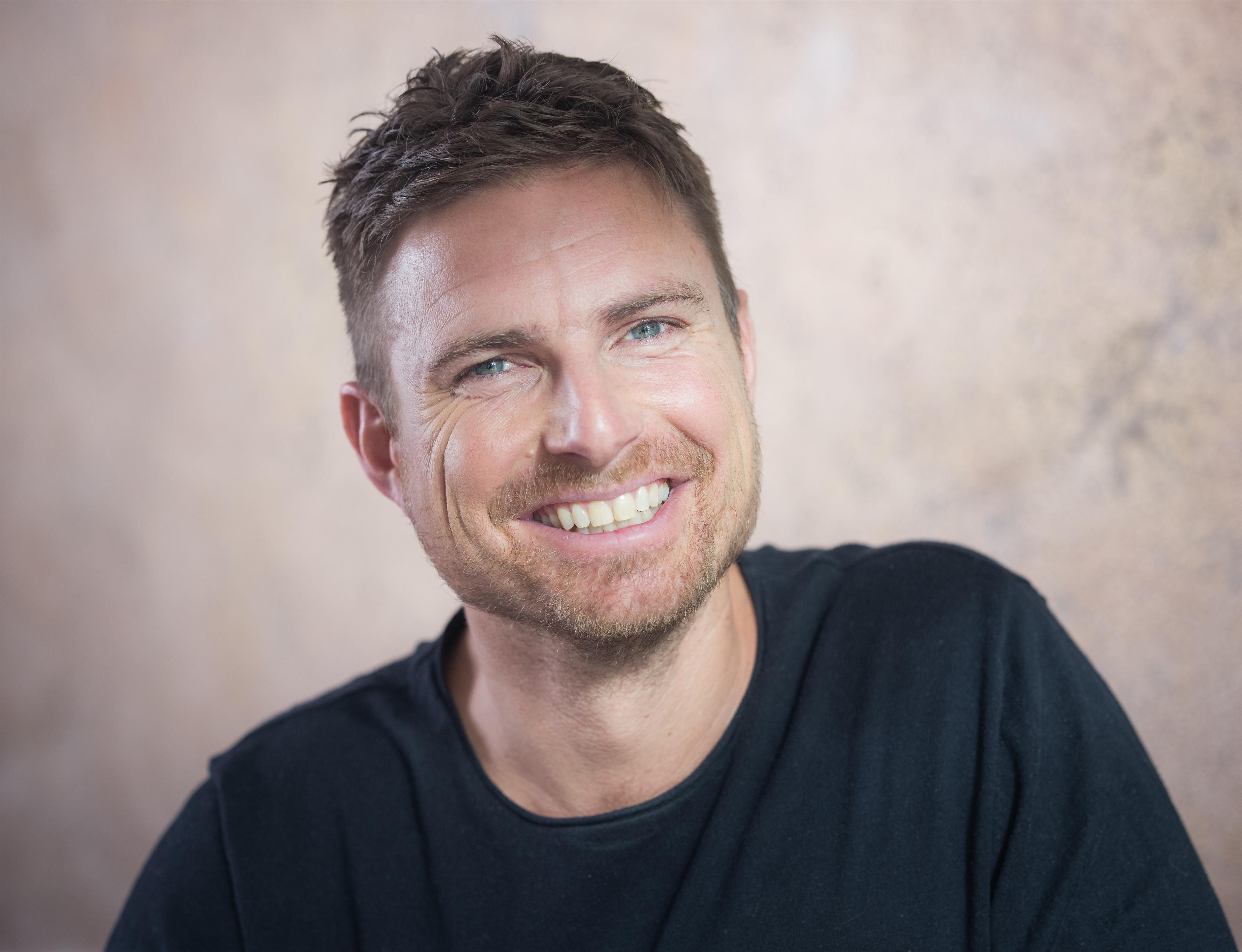 <p>Leo Reisinger im Portrait mit kurzen braunen Haaren und breitem Lachen.</p>