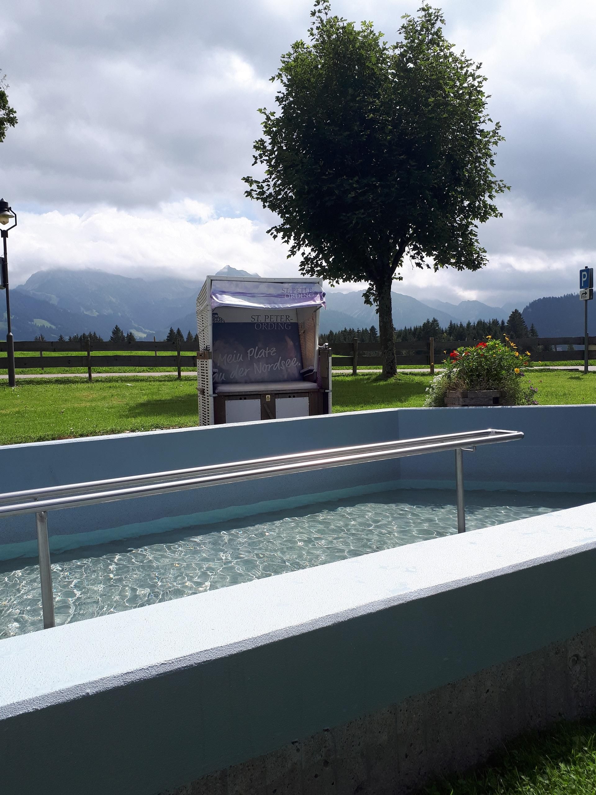 <p>Kneippbecken Bolsterlang im Kurpark Kitzebichl. Aussicht auf die Berge Entschenkopf und Rubihorn (hinter den Wolken).</p>