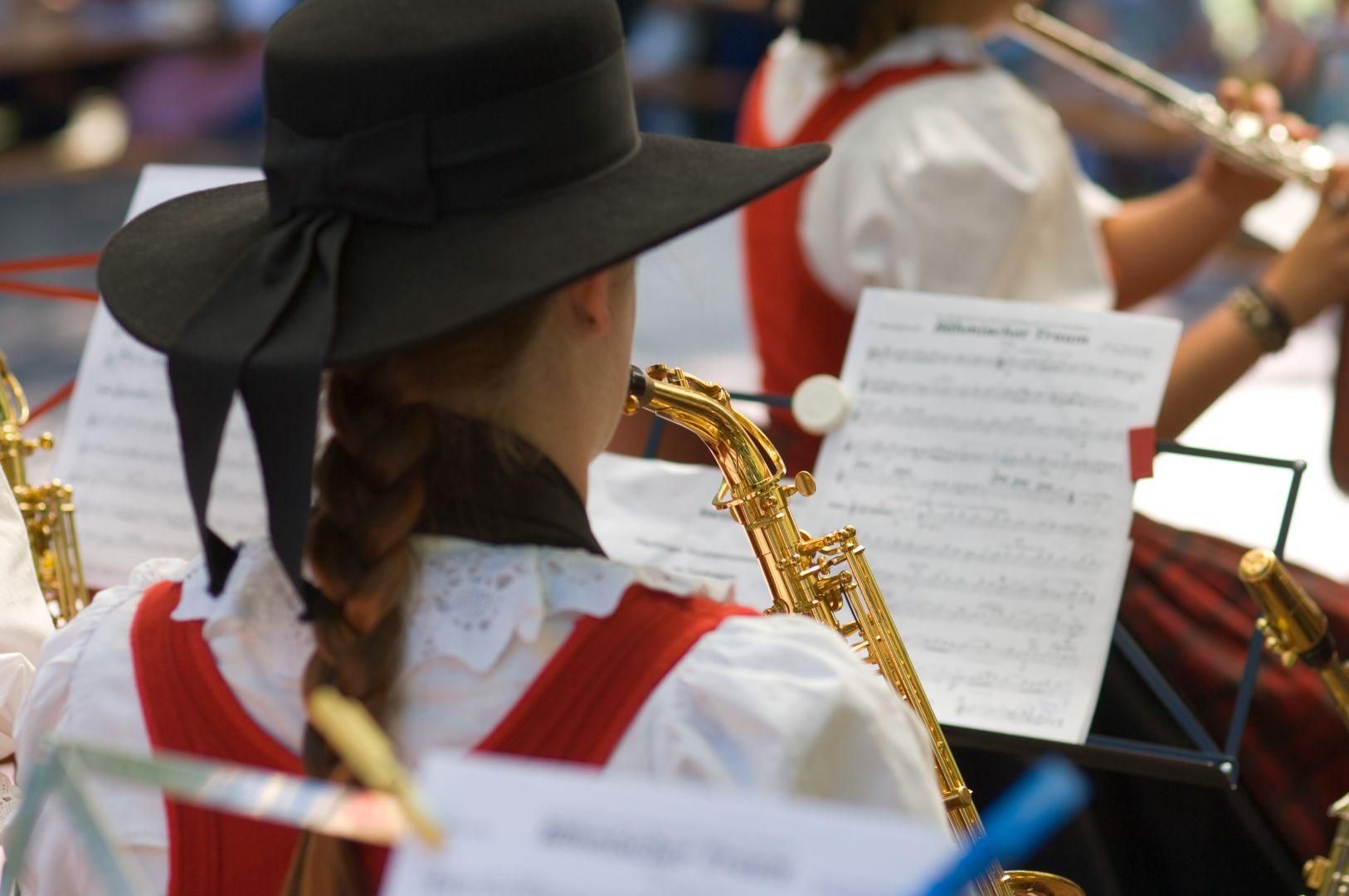 Bei einem Konzert der Musikkapelle Fischen: eine Frau mit geflochtenem Zopf und schwarzem Hut spielt vom Notenblatt.
