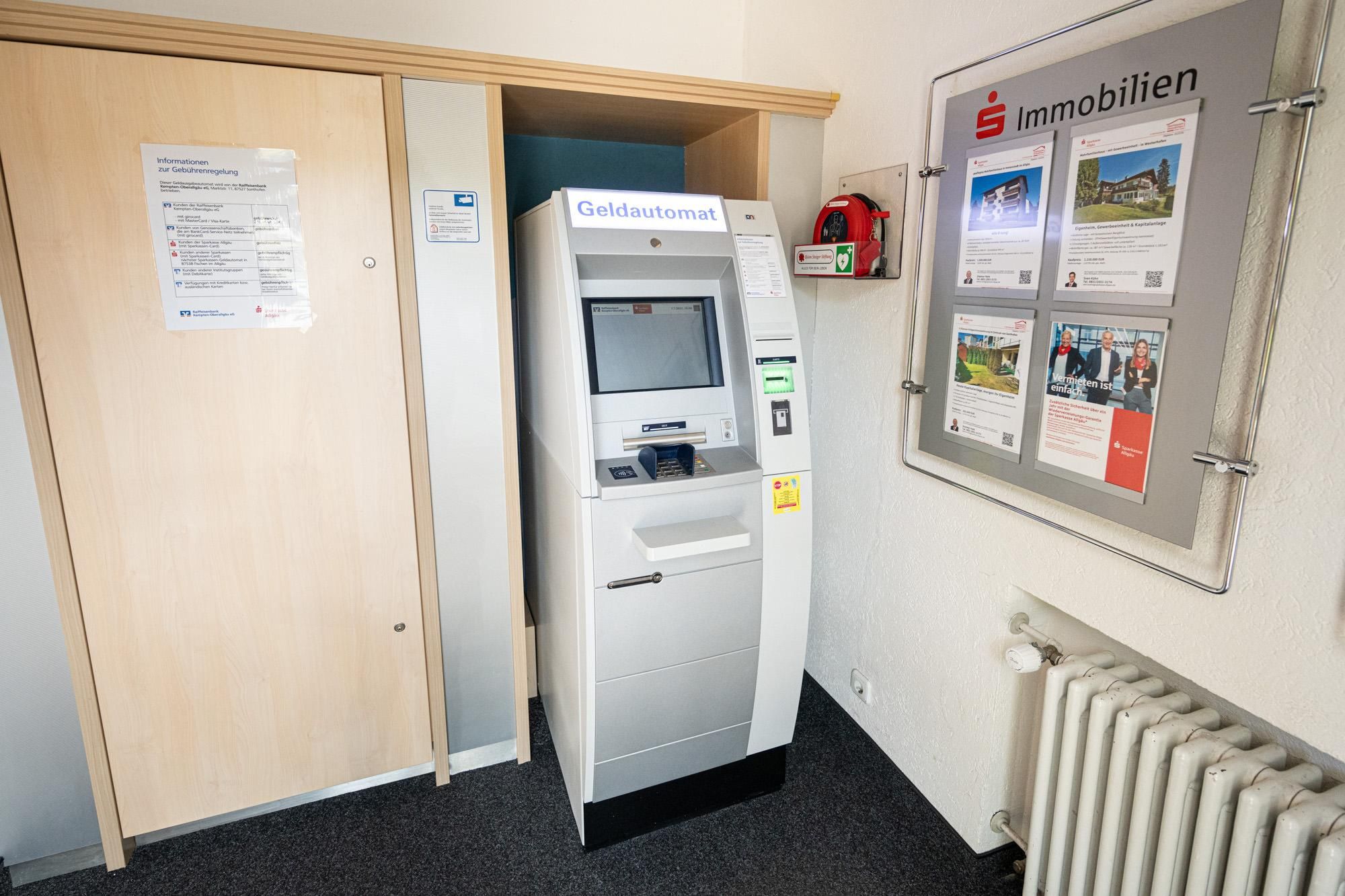 Silberfarbener Geldautomat mit blauem Bildschirm in Obermaiselstein.
