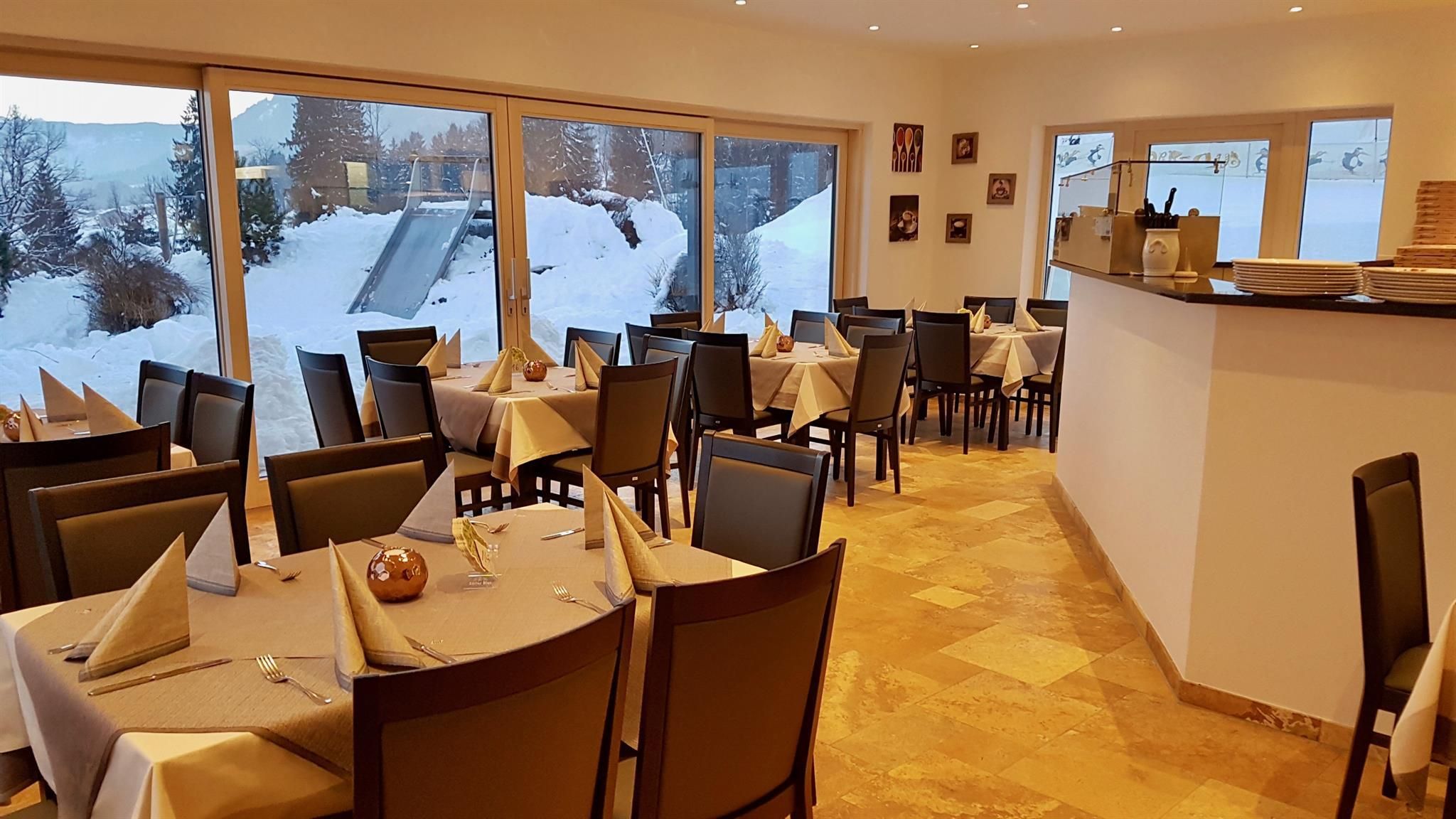 Logo des "Ristorante-Pizzeria Cortina" mit einer stilisierten Darstellung eines Pizzaofens mit Flammen vor einer grauen Bergkulisse.