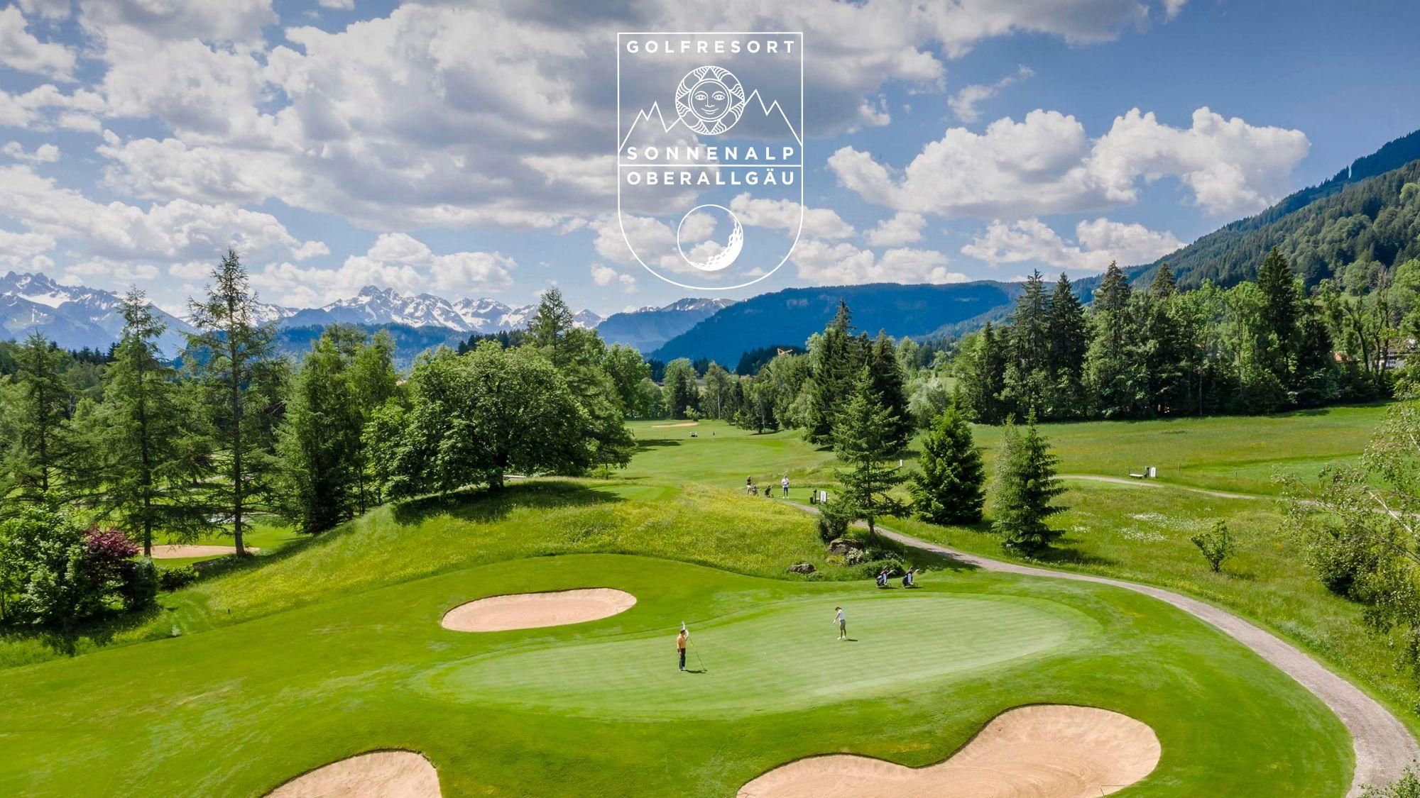 Weitläufiger, grüner Golfplatz Sonnenalp Oberallgäu mit sanften Hügeln und Sandbunkern. Einzelne Golfer sind auf dem Platz zu sehen.