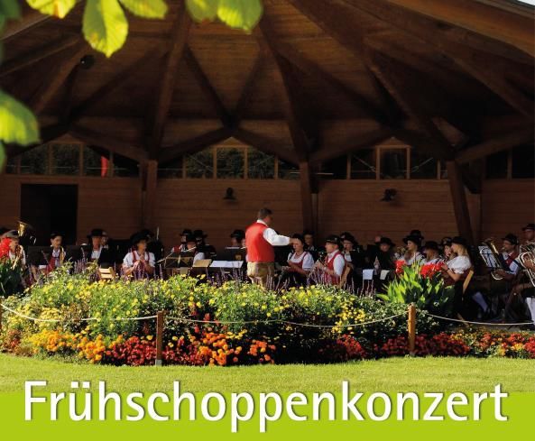Eine Musikkapelle im Musikpavillon vor dem Kurhaus Fiskina, Schriftzug Frühschoppenkonzert
