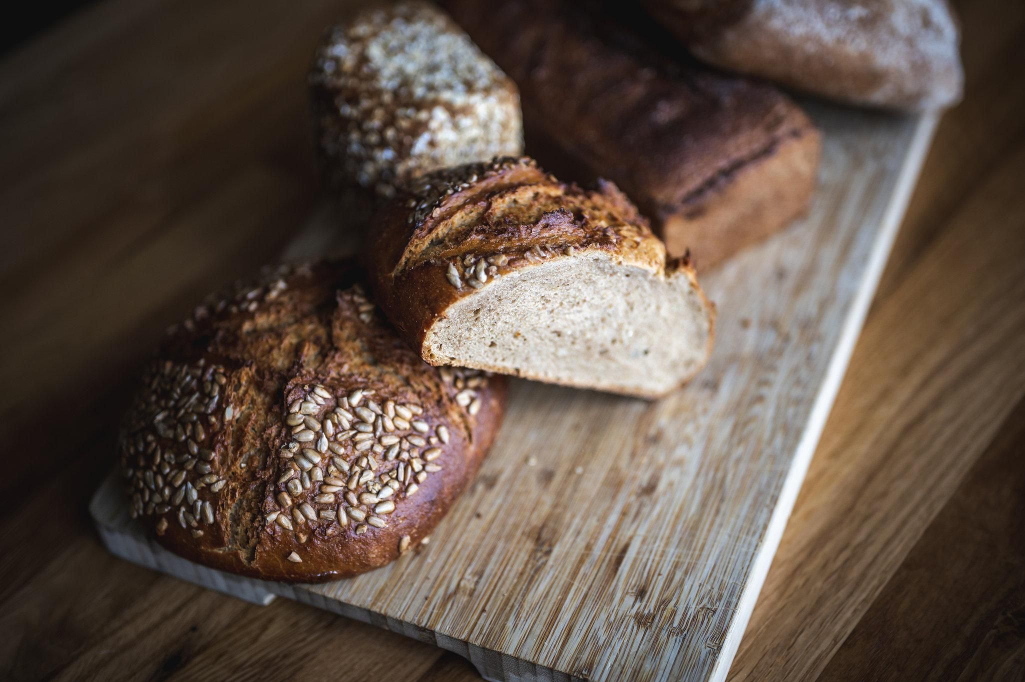 Eine Nahaufnahme zeigt verschiedene Brotsorten auf einem Holzbrett.