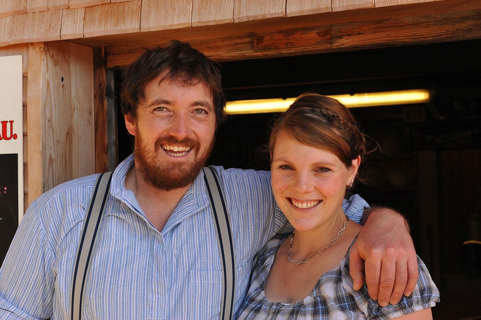 Ein Porträt zeigt zwei Personen. Beide lächeln und schauen in die Kamera.