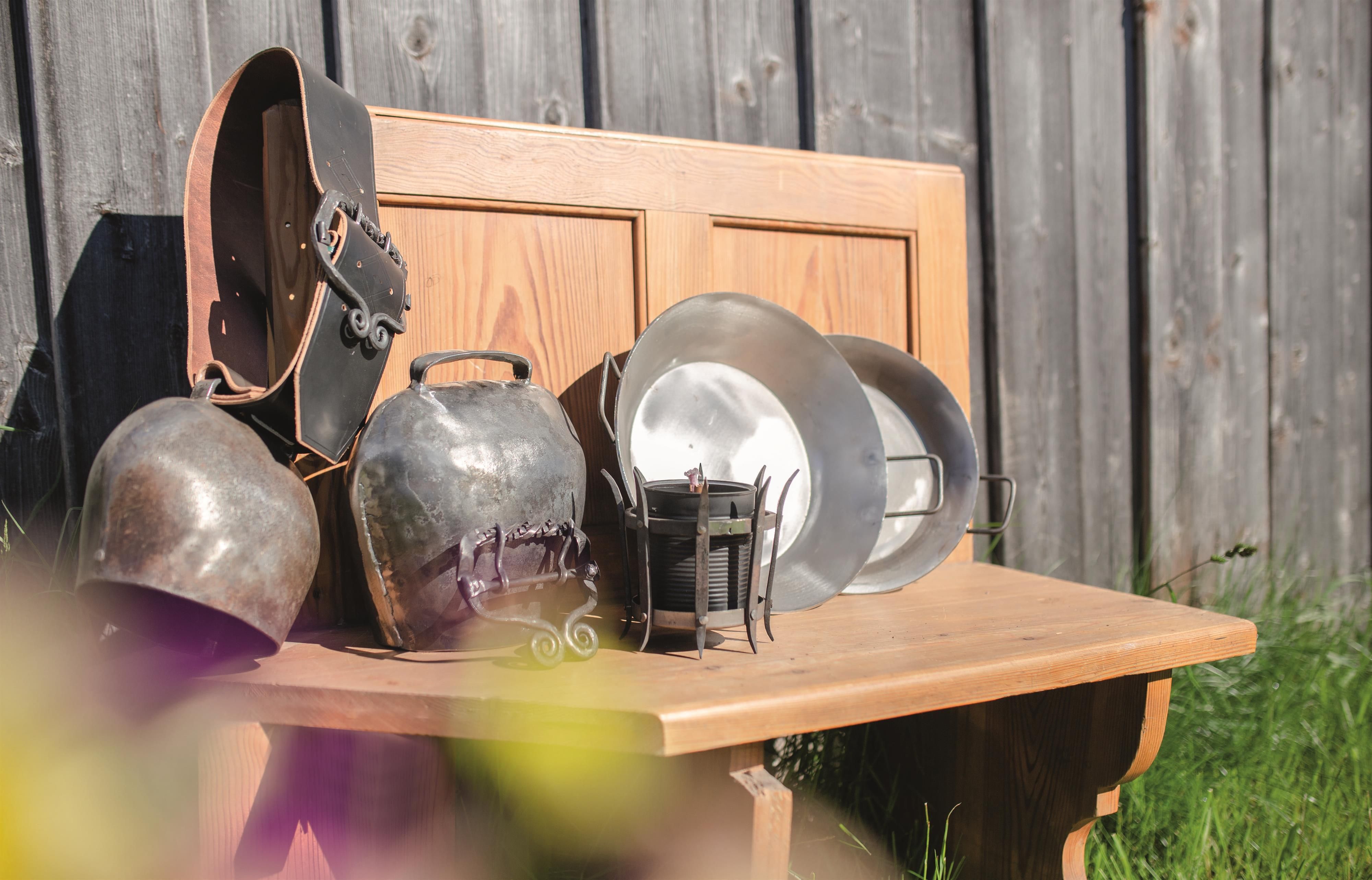 Schmiede-Werke sind auf einem Holztisch ausgestellt.