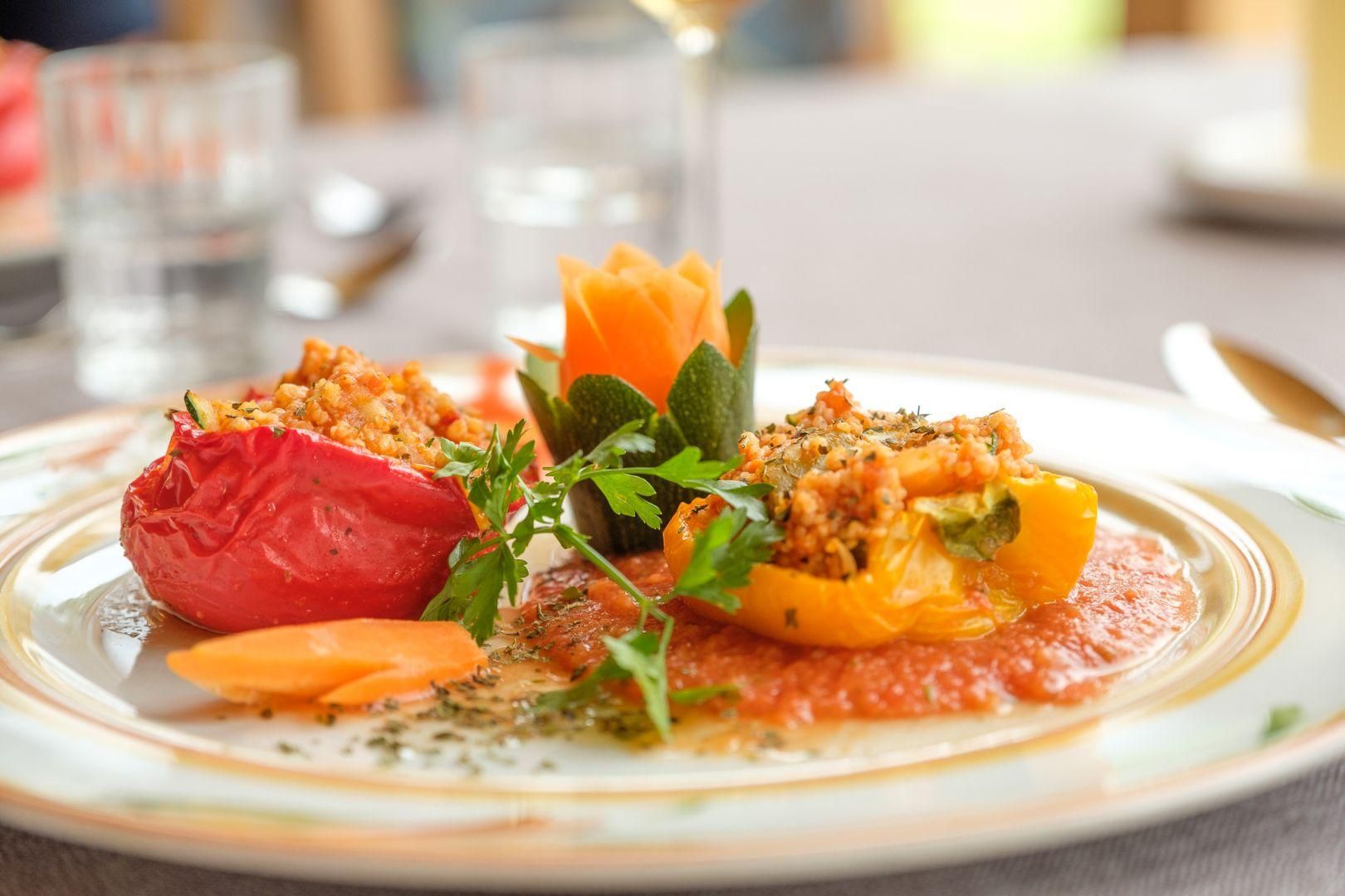 Ein Teller mit zwei gefüllten Paprika in den Farben Rot und Gelb