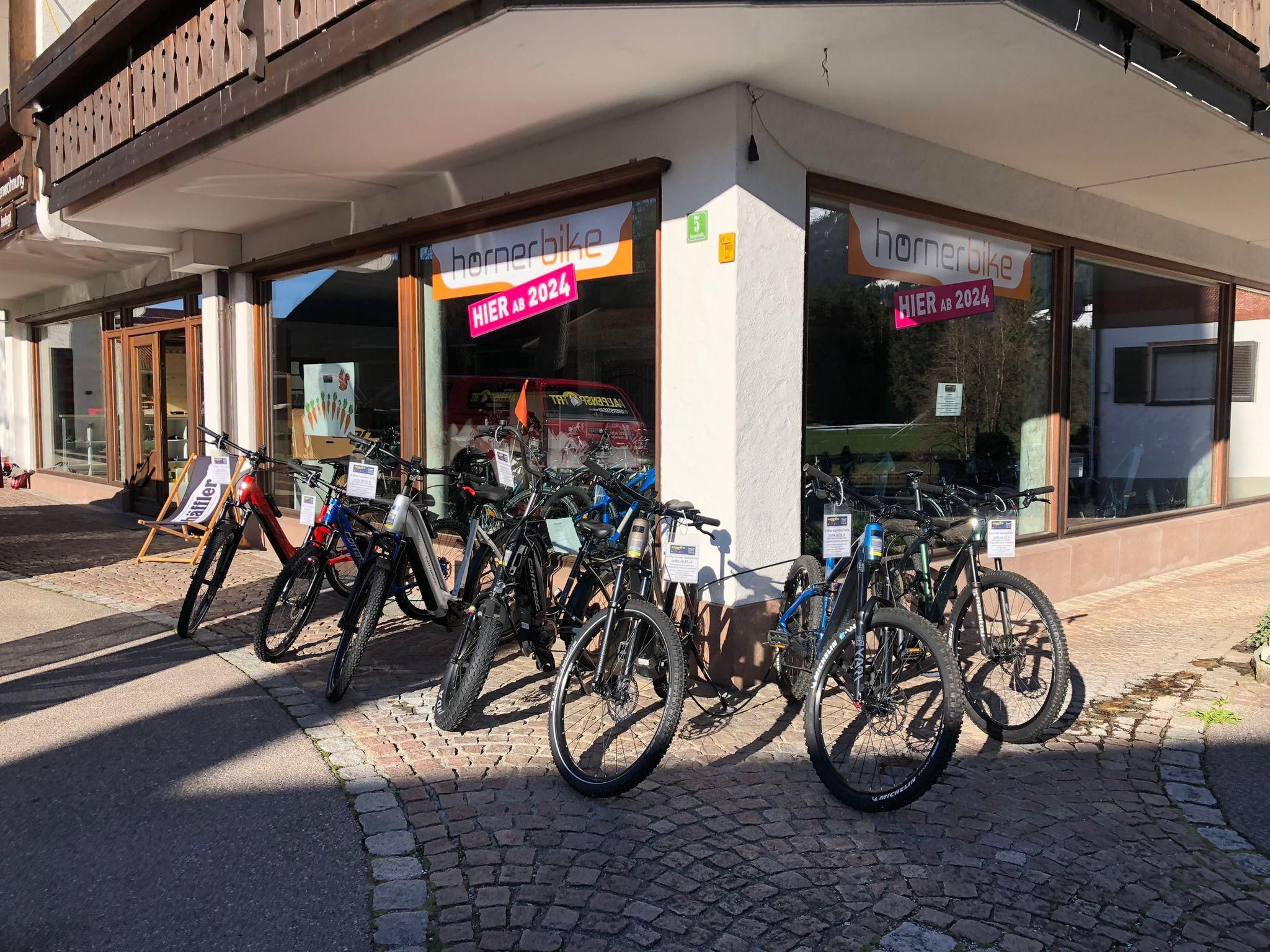 Vor dem Geschäft Hörnerbike stehen sieben verschiedene E-Bikes.