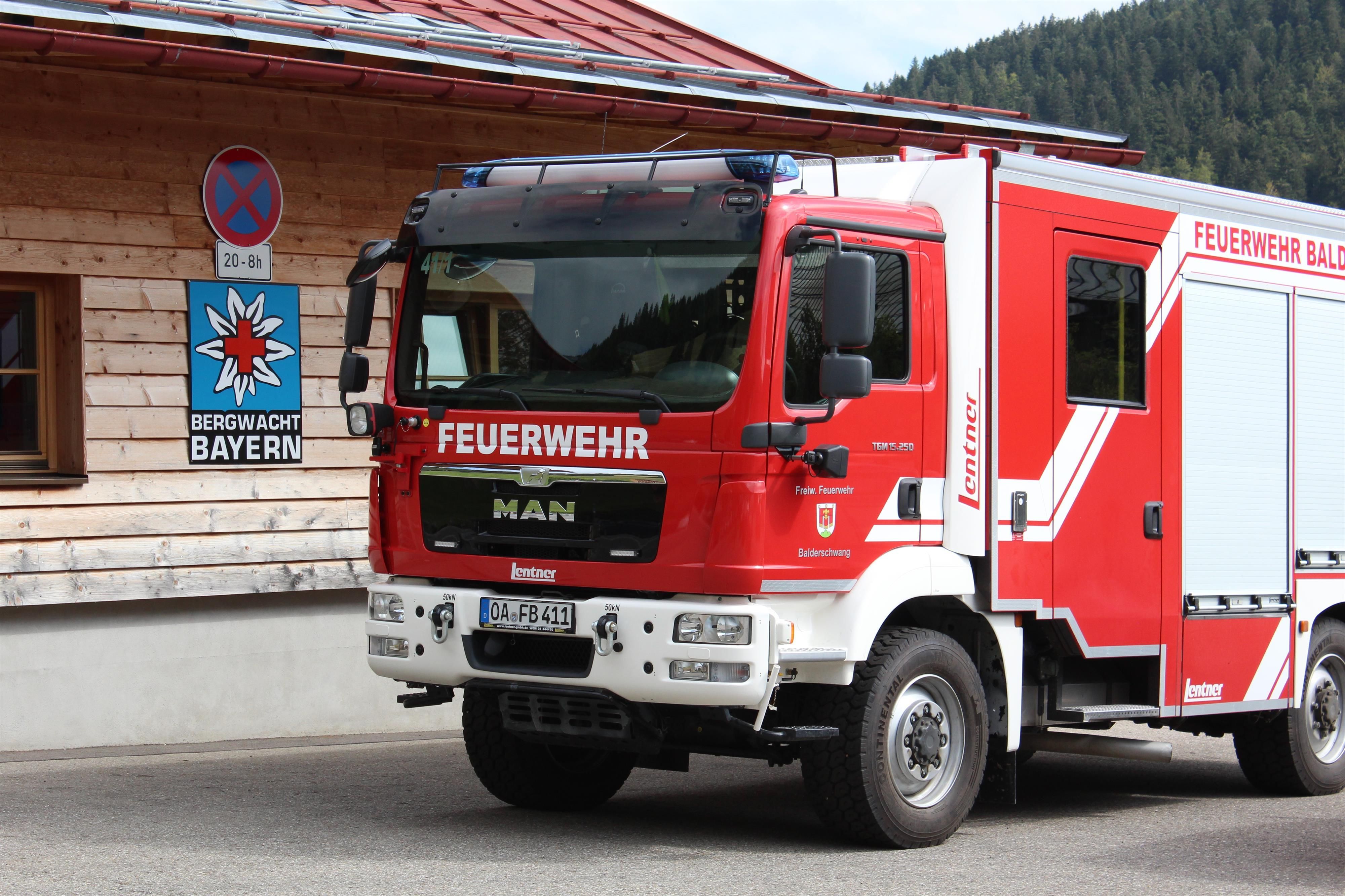 Feuerwehauto steht vor einem Bergwachthaus.