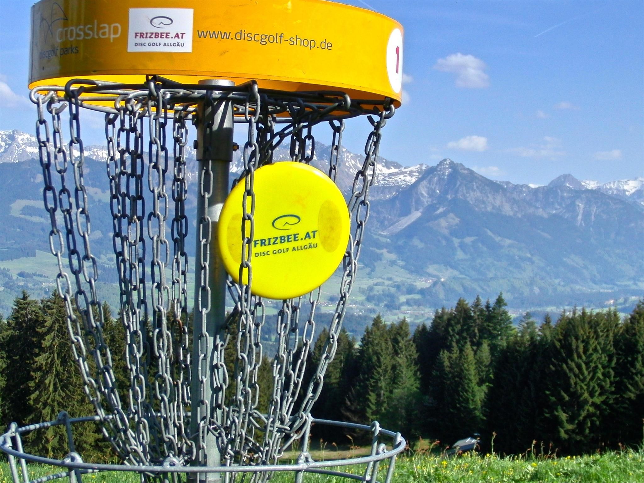 Gelber Disc Golf Korb mit gelber Frisbeescheibe.