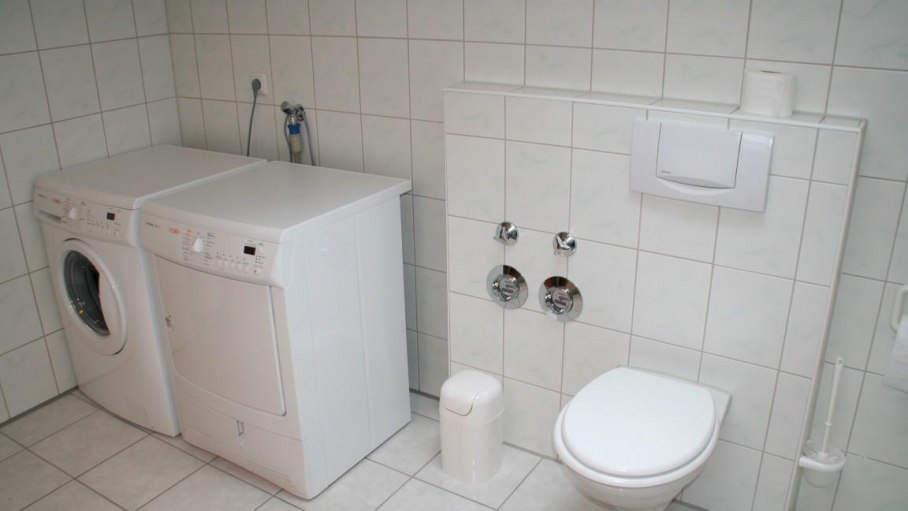 Badezimmer mit WC, Waschmaschine und Wäschetrockne