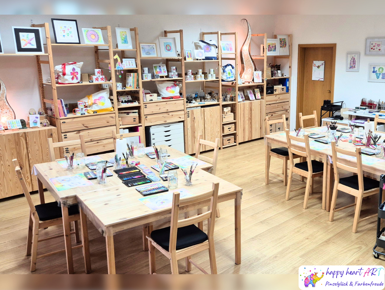 Je zwei Stühle pro Tisch, vorbereitet sind unterschiedliche Farben zur Benutzung, im Regal dahinter weitere Utensilien.