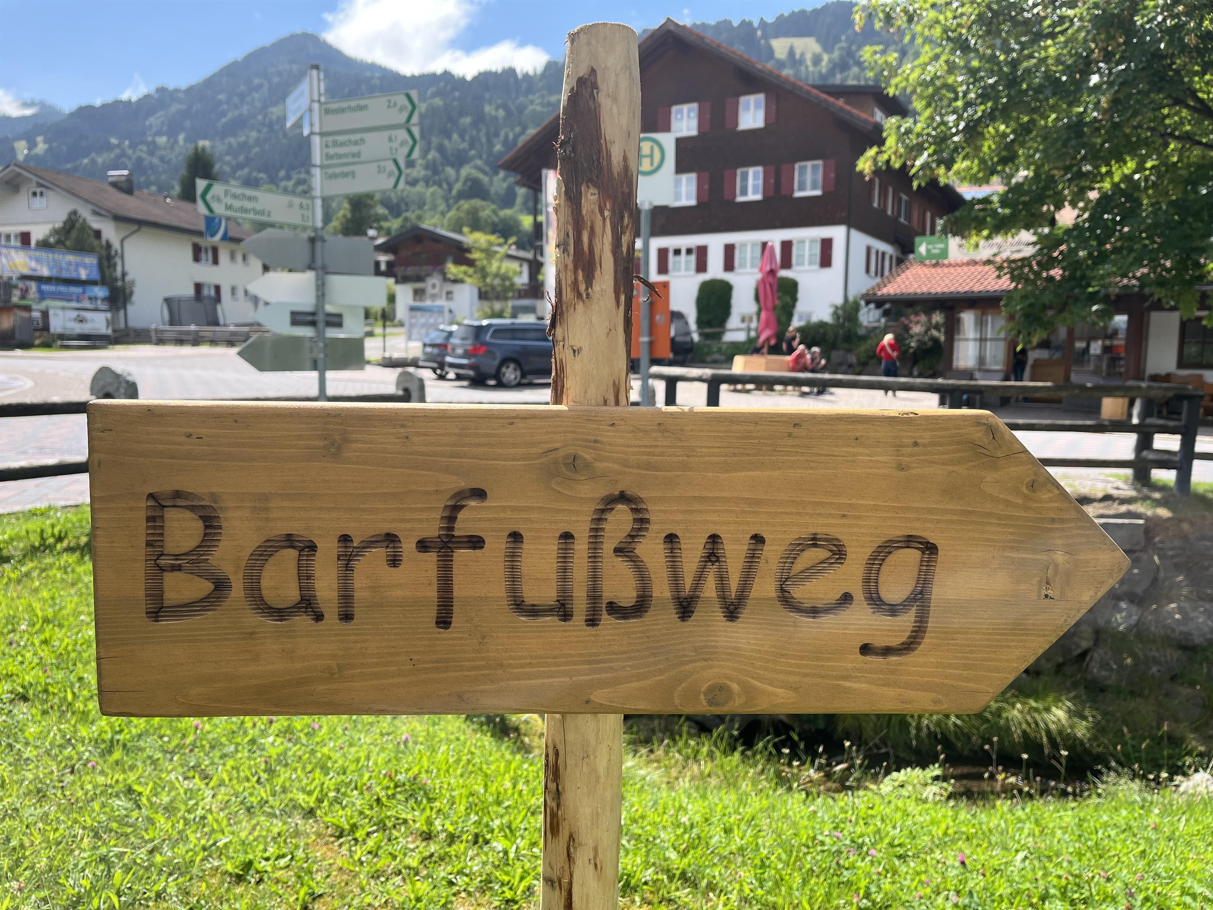 Ein hölzernes Wegweiserschild mit der Aufschrift "Barfußweg"