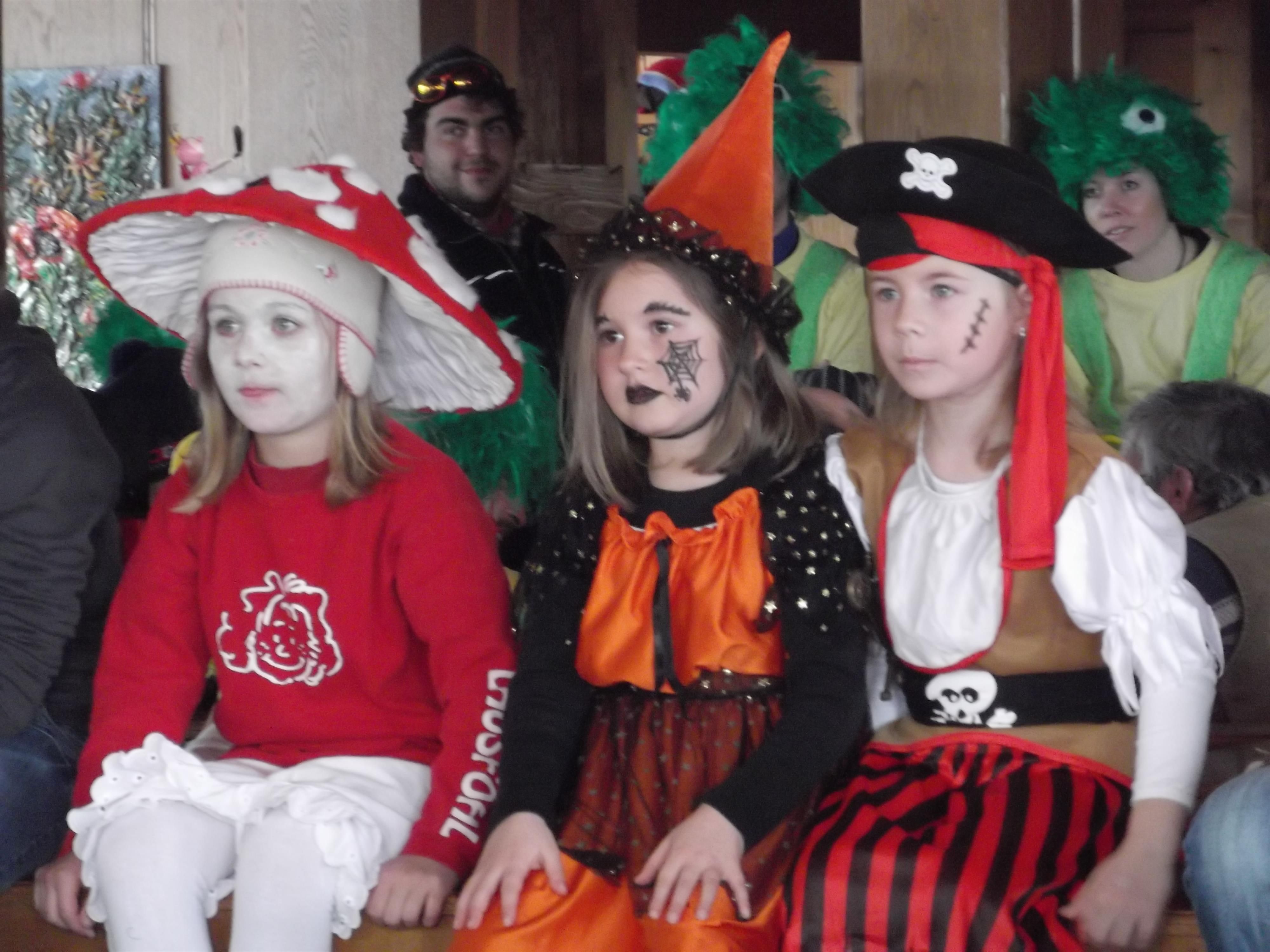 Drei verkleidete Kinder beim Fasching: Fliegenpilz, Hexe und Pirat im Vordergrund.