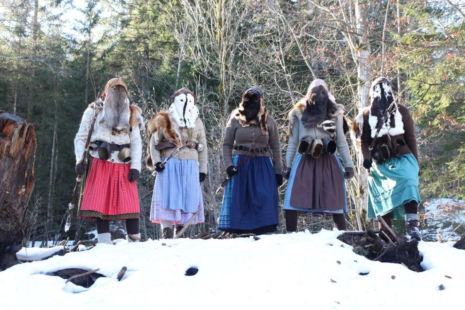 Tradiotionellen Bärbele stehen auf einem Schneehaufen.