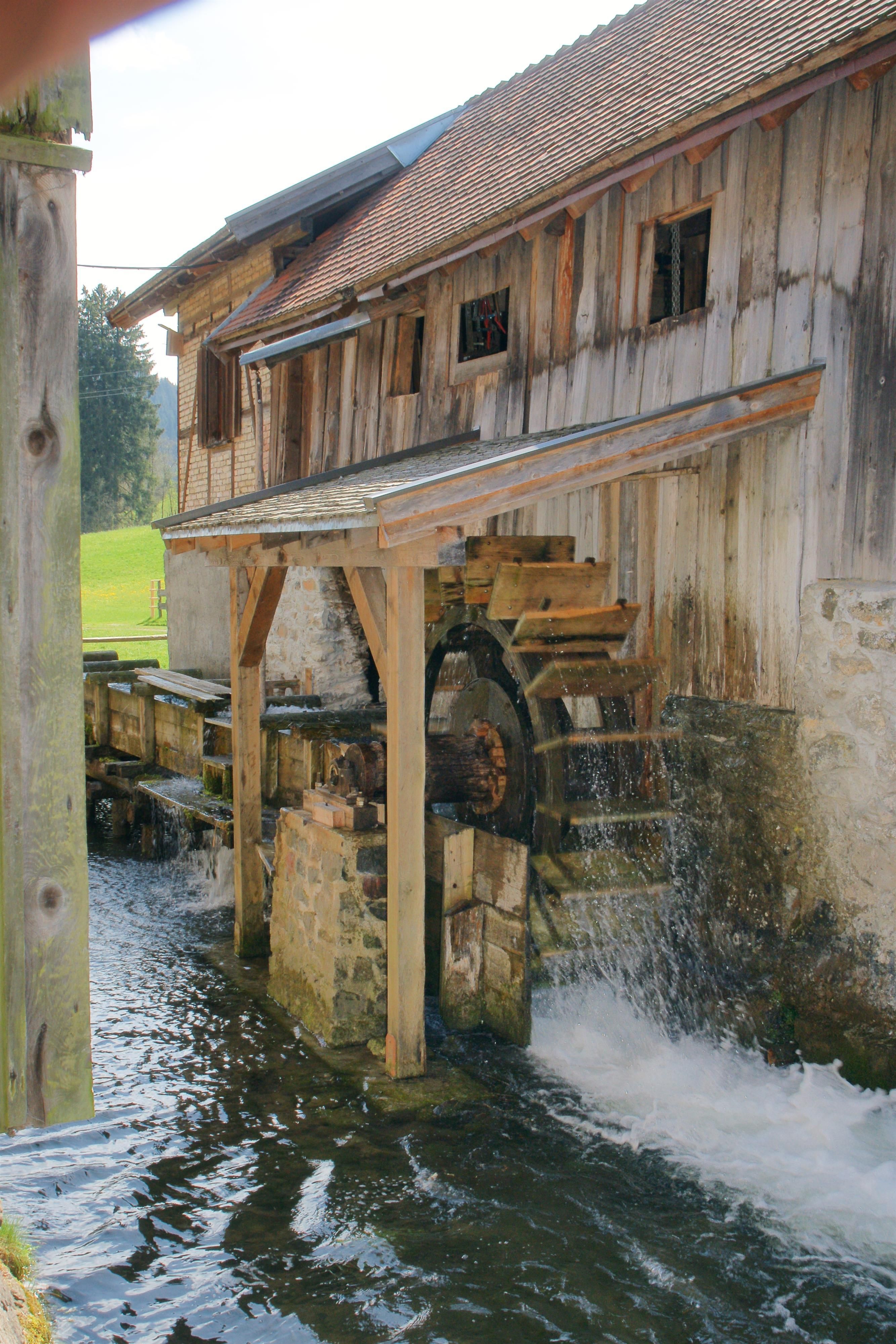 Das Wasserrad wird vom vorbeifließenden Bach angetrieben.