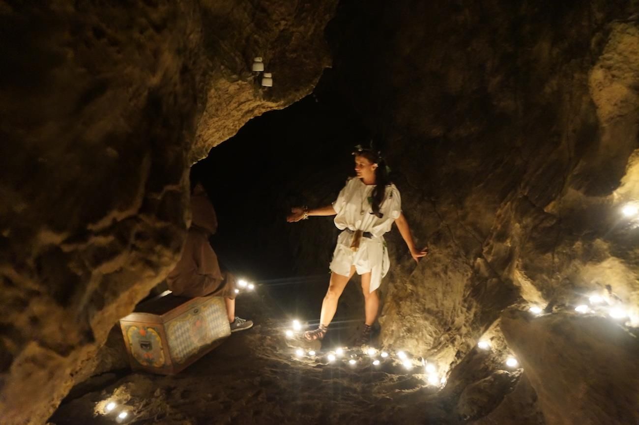 Im Dunkeln leuchtet eine Fackel hell, dahinter verschwommene Lichter.