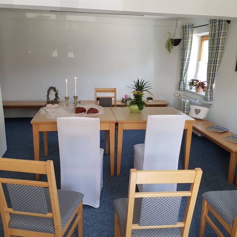 Standesamtliche Trauung im Lesezimmer der Gästeinformation im Rathaus Bolsterlang. Schlicht gedeckter Tisch, Stühle für Brautpaar mit weißen Stuhlhussen.