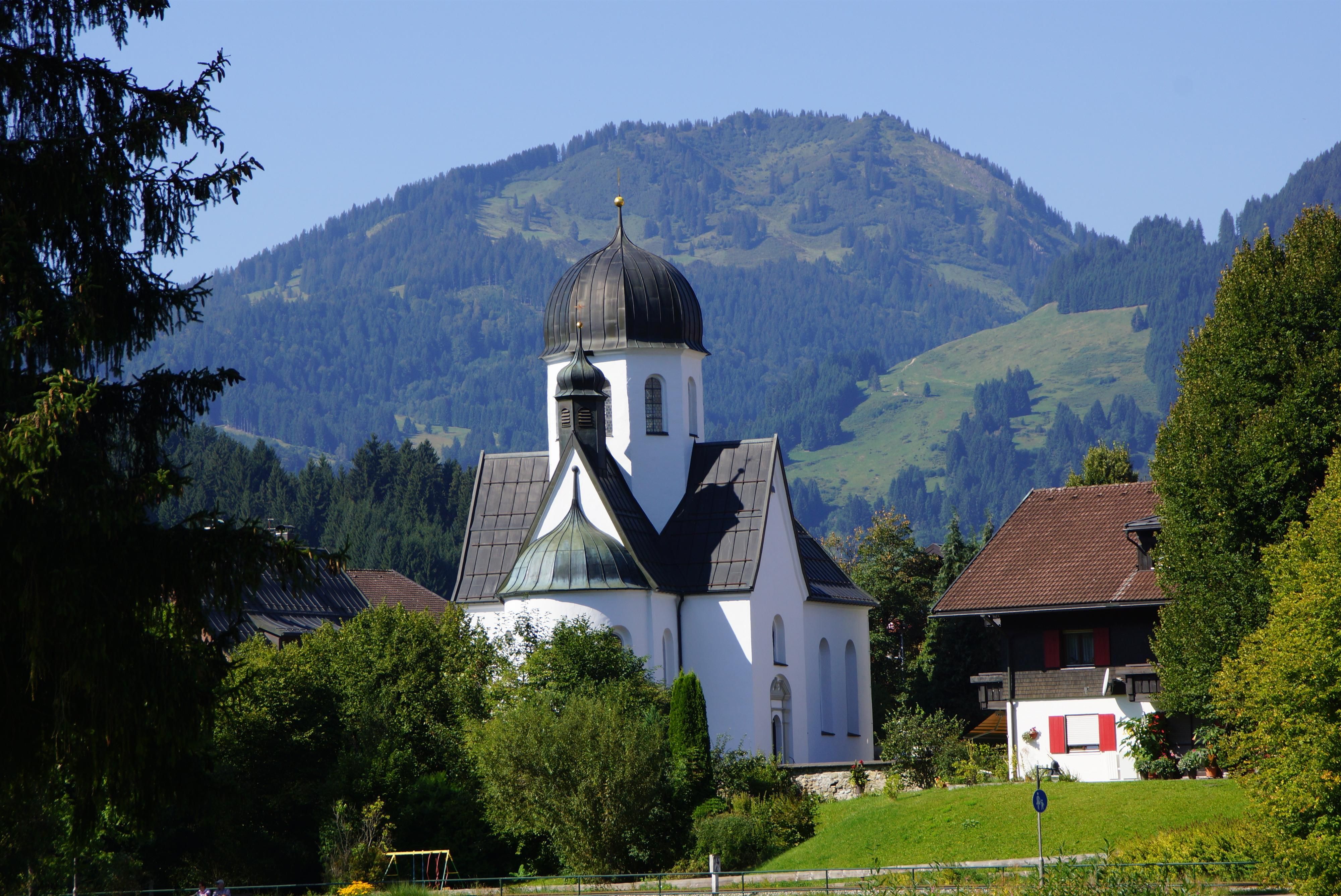 Die Frauenkapelle in Fischen, ein weißes Gebäude mit schwarzem Dach.
